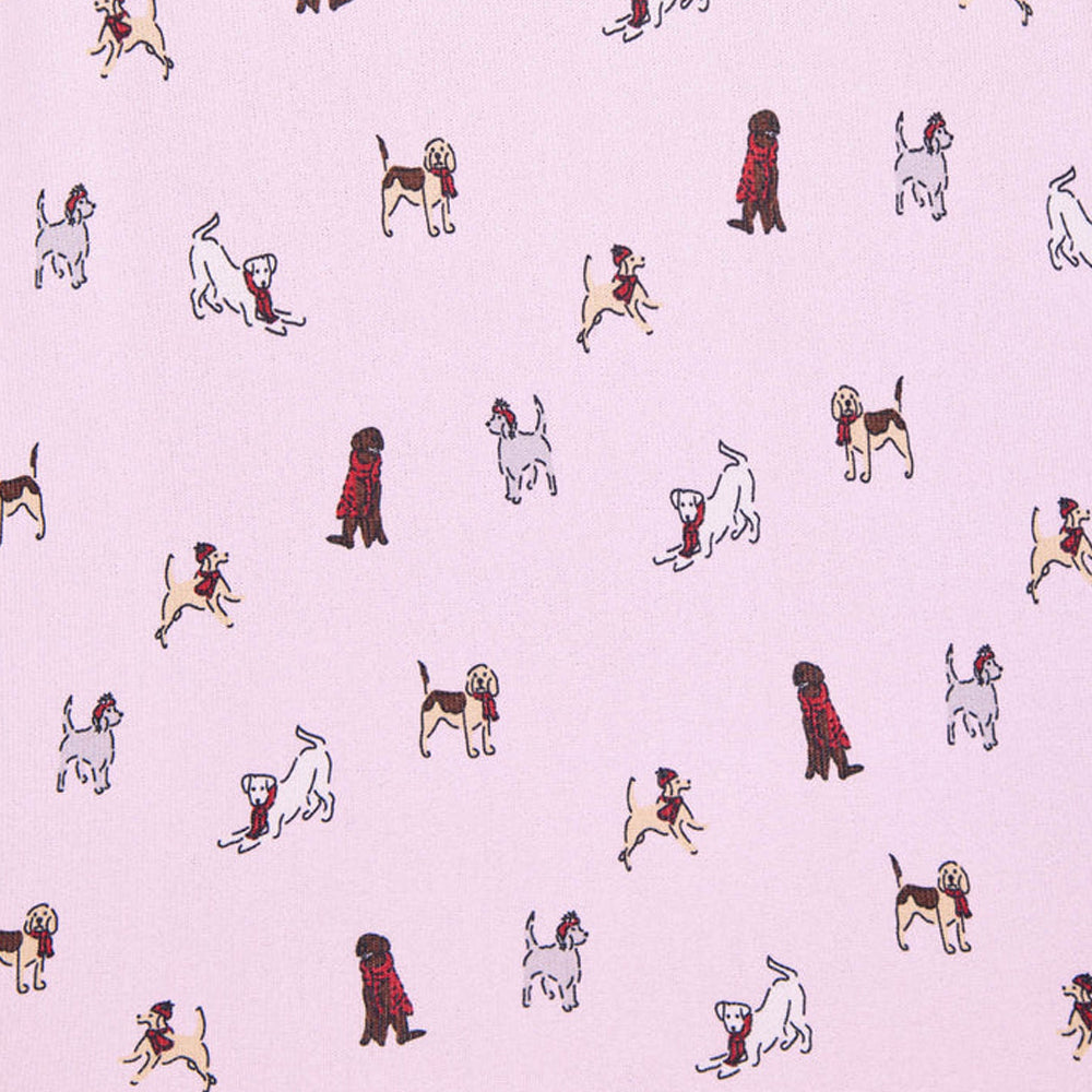 Close-up of Splendid Cozy Canines light pink pajama fabric featuring illustrated dogs in different breeds and poses, with festive red scarves and accents.