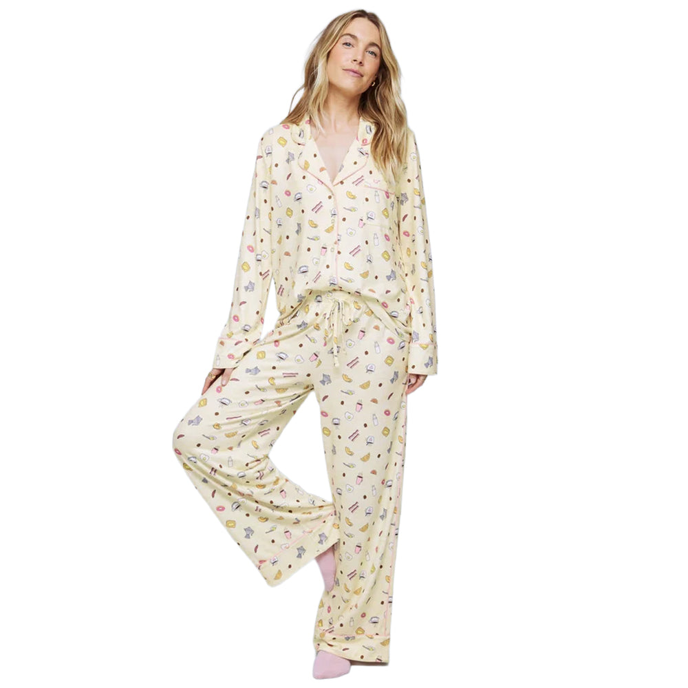 Model wearing Splendid Pillowsoft PJ Set in cream with playful breakfast print, featuring a long-sleeve button-up top and matching wide-leg pants.