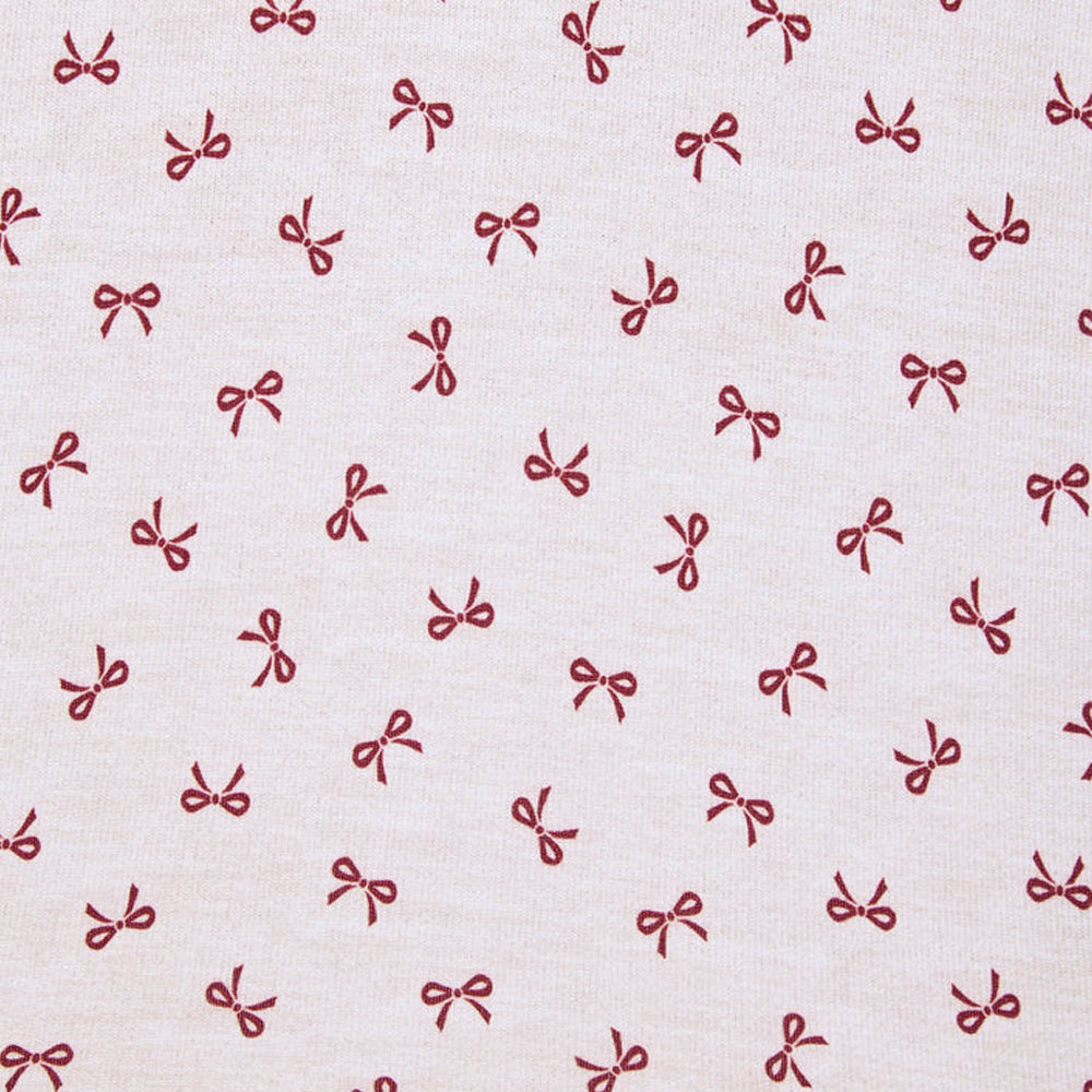 Close-up of Splendid Pillowsoft white pajama fabric featuring an all-over burgundy bow print.