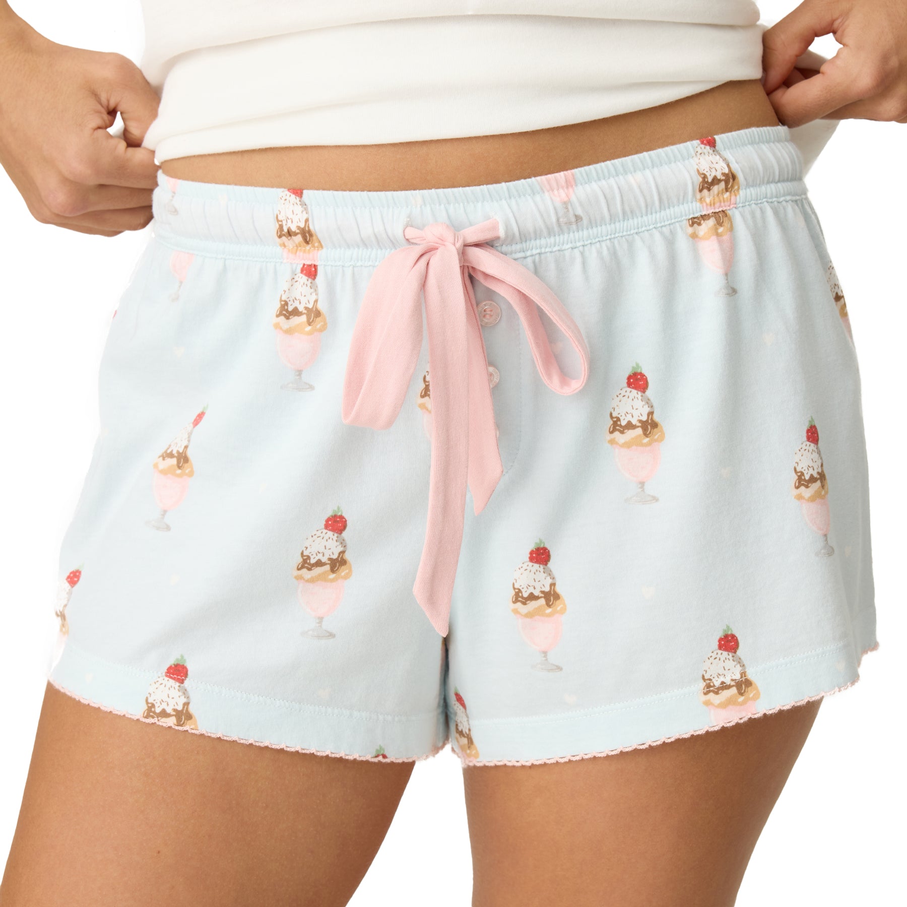 Light blue pajama shorts with ice cream cone pattern and pink drawstring on a white background