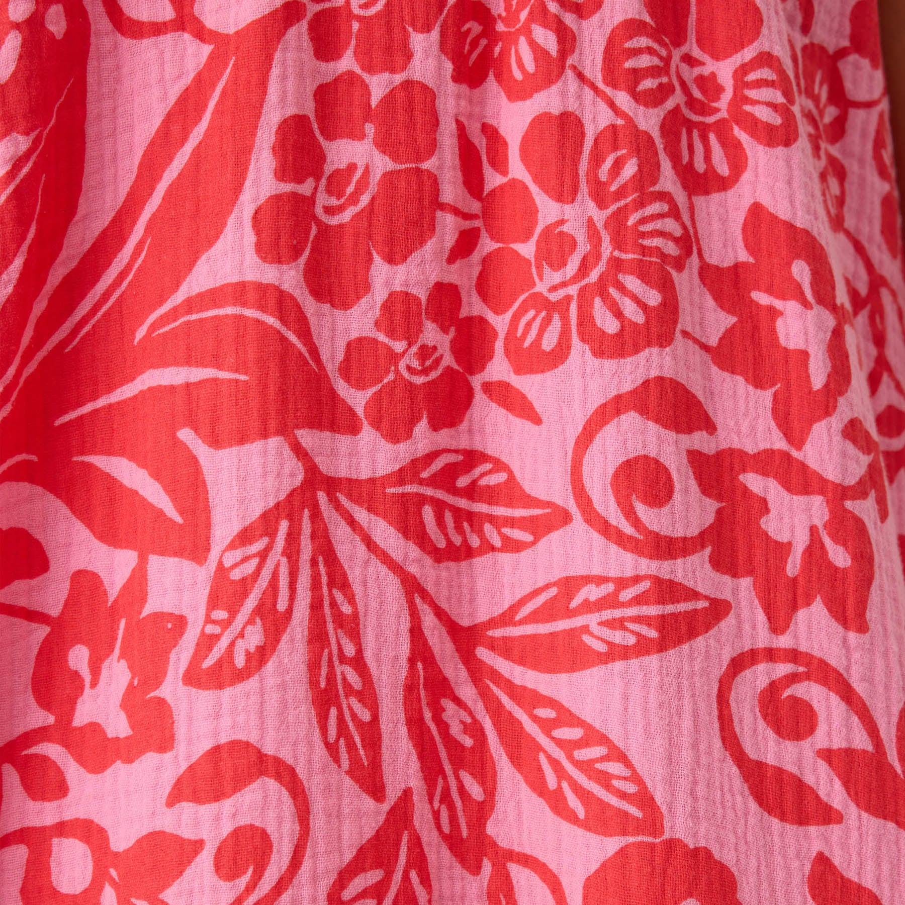 Close-up of pink and red floral print fabric with leaf and flower pattern