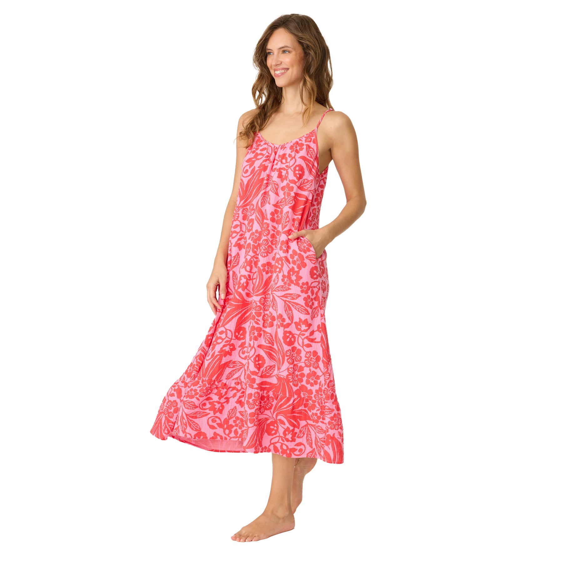 Side view of woman wearing flowing pink and red floral print midi dress with pockets