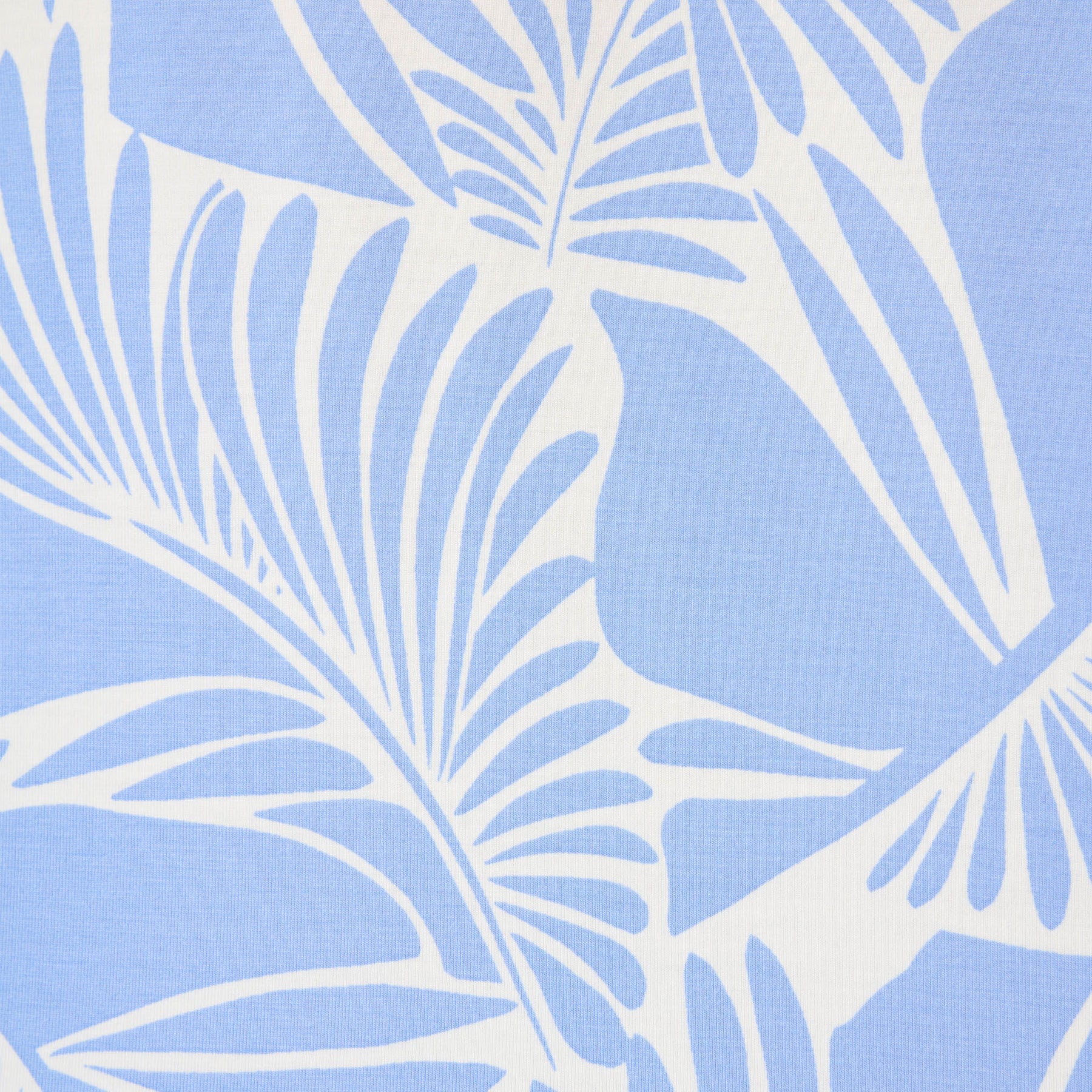 Close-up detail of blue and white tropical leaf print fabric.