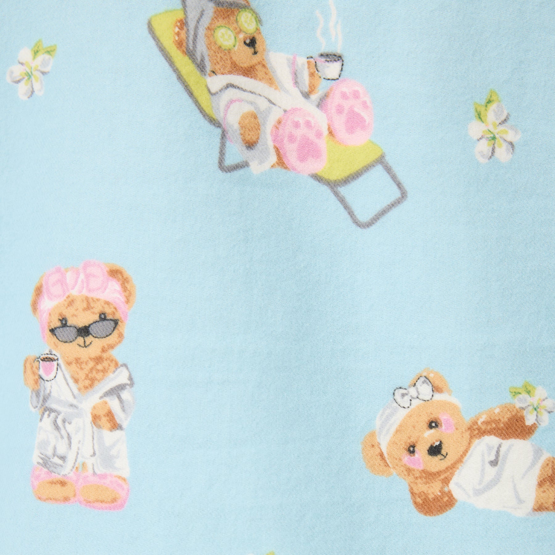 Fabric close-up showing bears in robes with coffee cups on light blue background.
