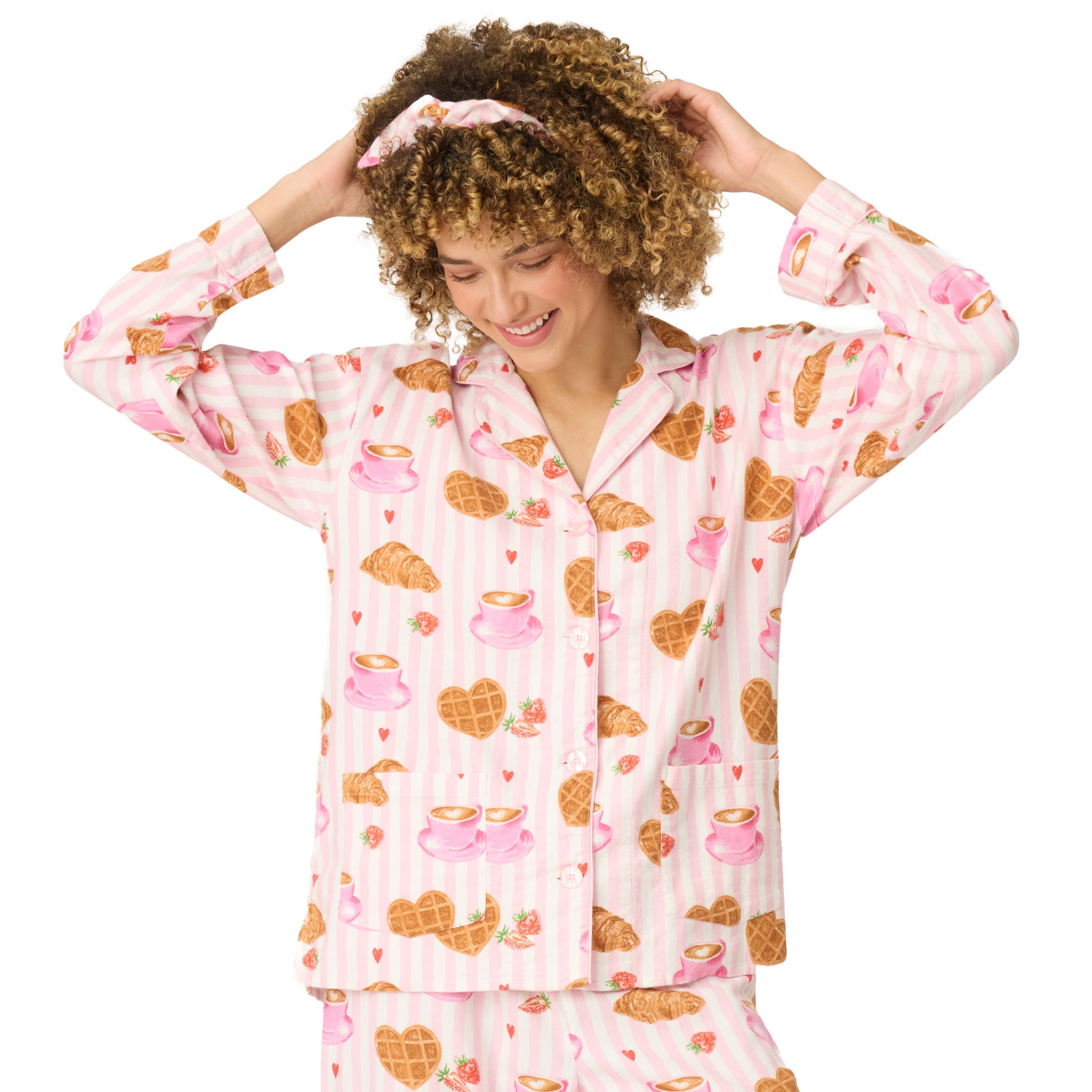 Woman smiling in button-front pink striped pajama top with breakfast print.