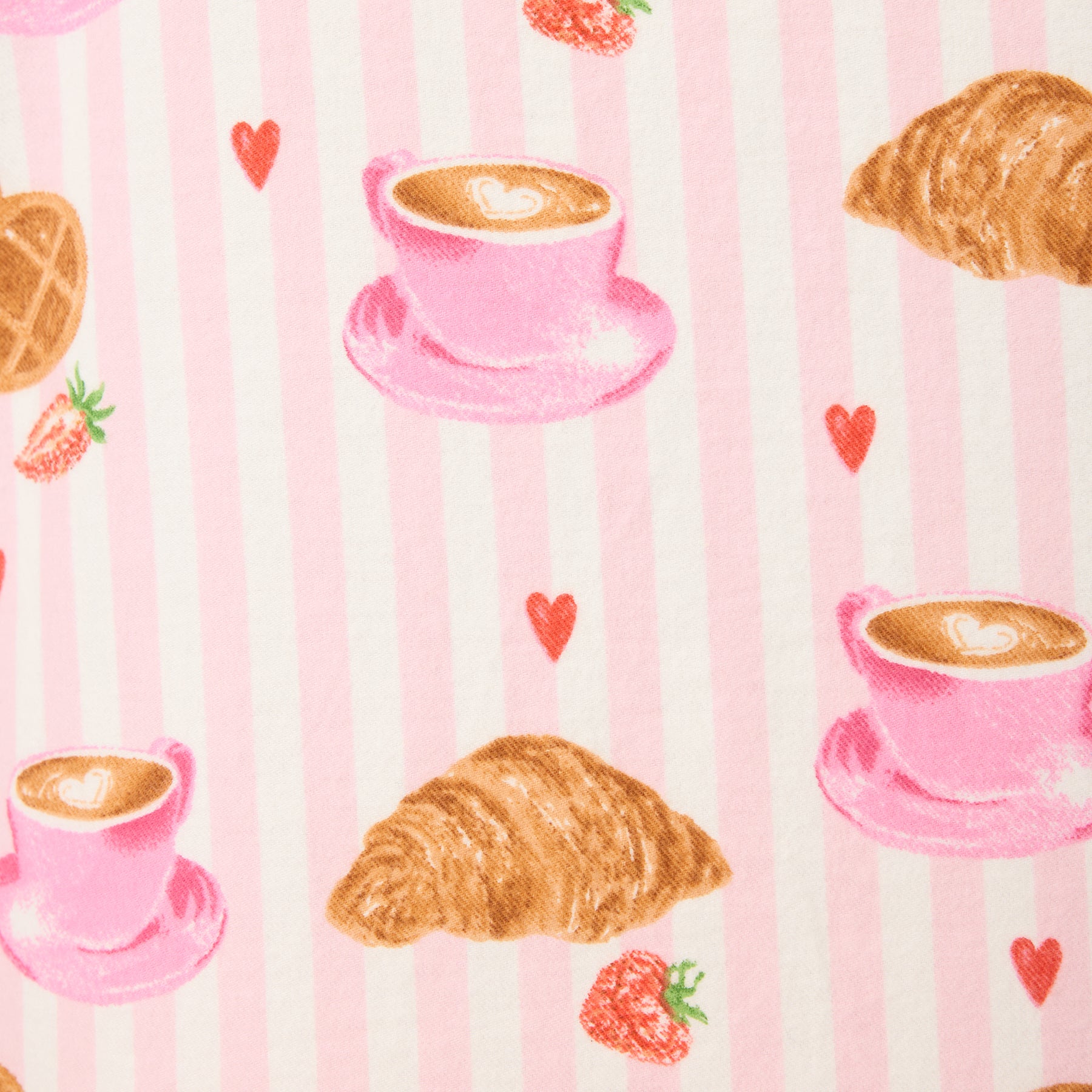 Fabric close-up of pink stripes with coffee cups, croissants, and strawberries.