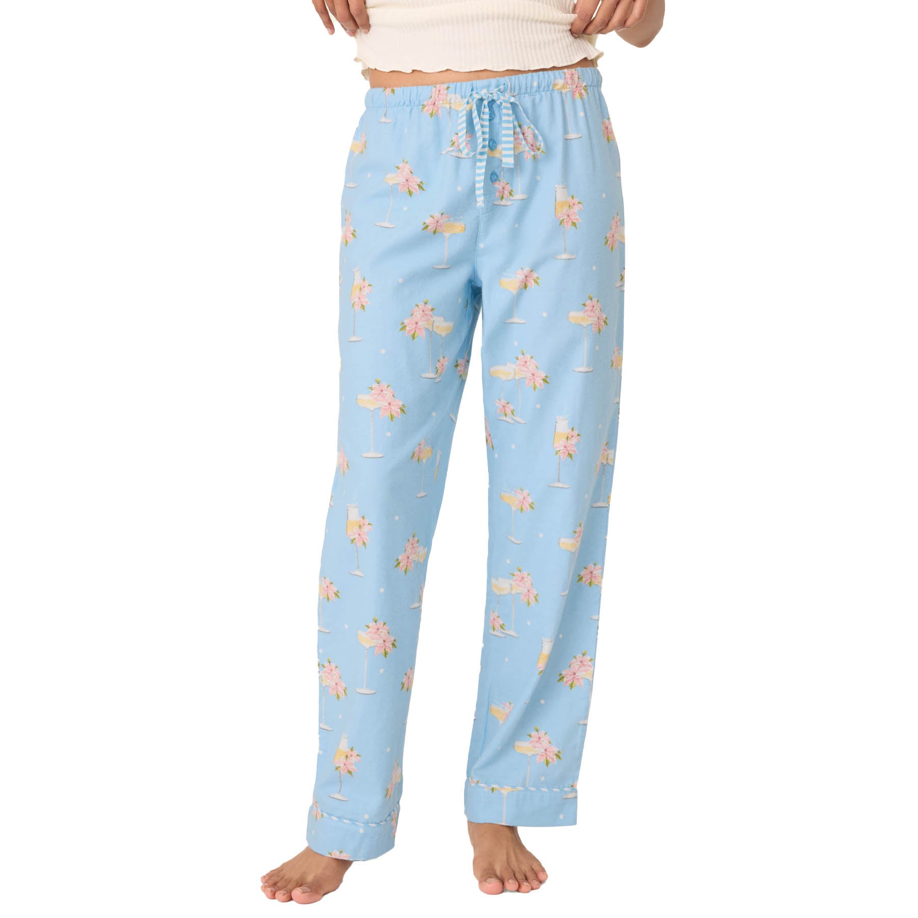 Light blue pajama pants with floral pattern worn by a person on a white background