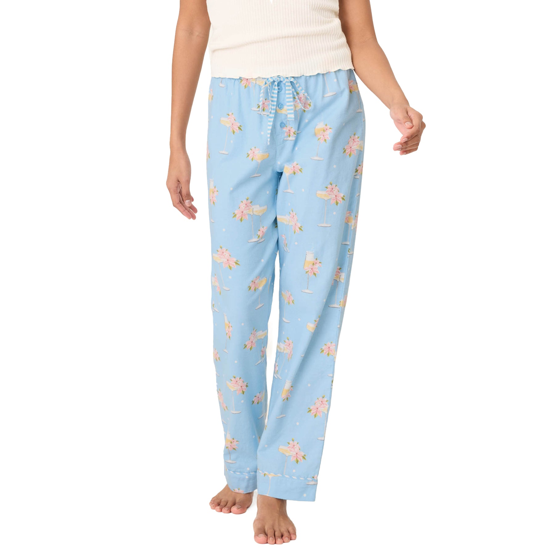 Light blue pajama pants with a floral pattern worn by a person on a white background