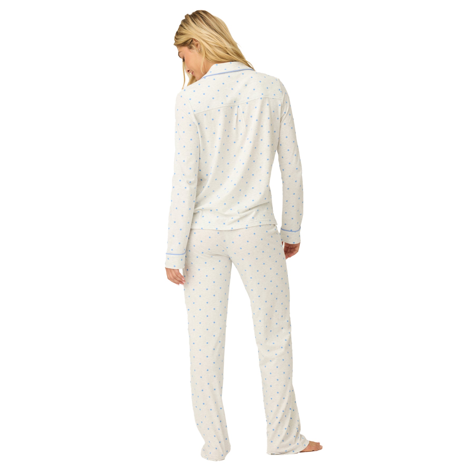 Woman wearing a white pajama set with a subtle pattern on a white background