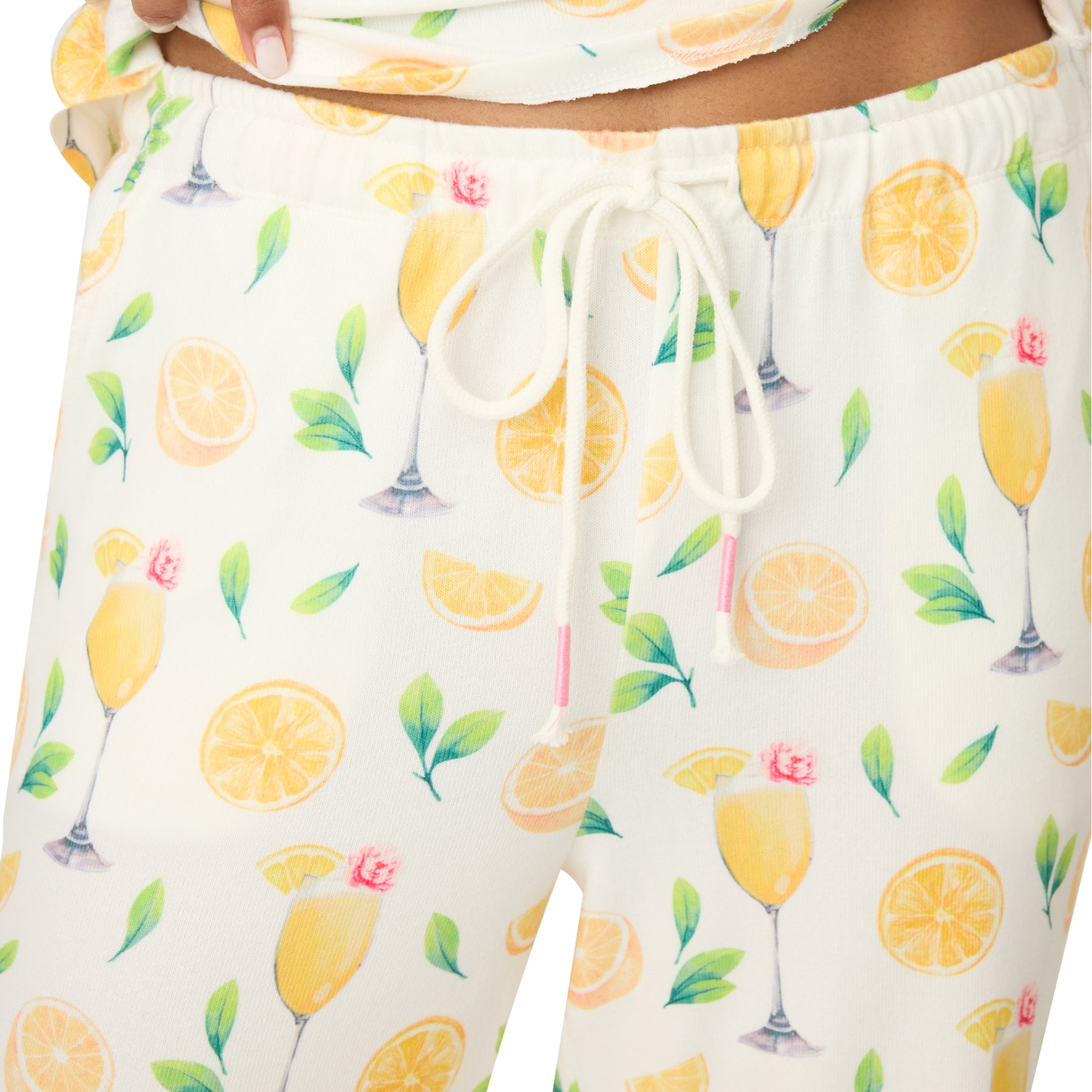 Close-up of the drawstring waistband on ivory pyjama pants with a citrus and cocktail print, showing the soft texture and playful pattern.