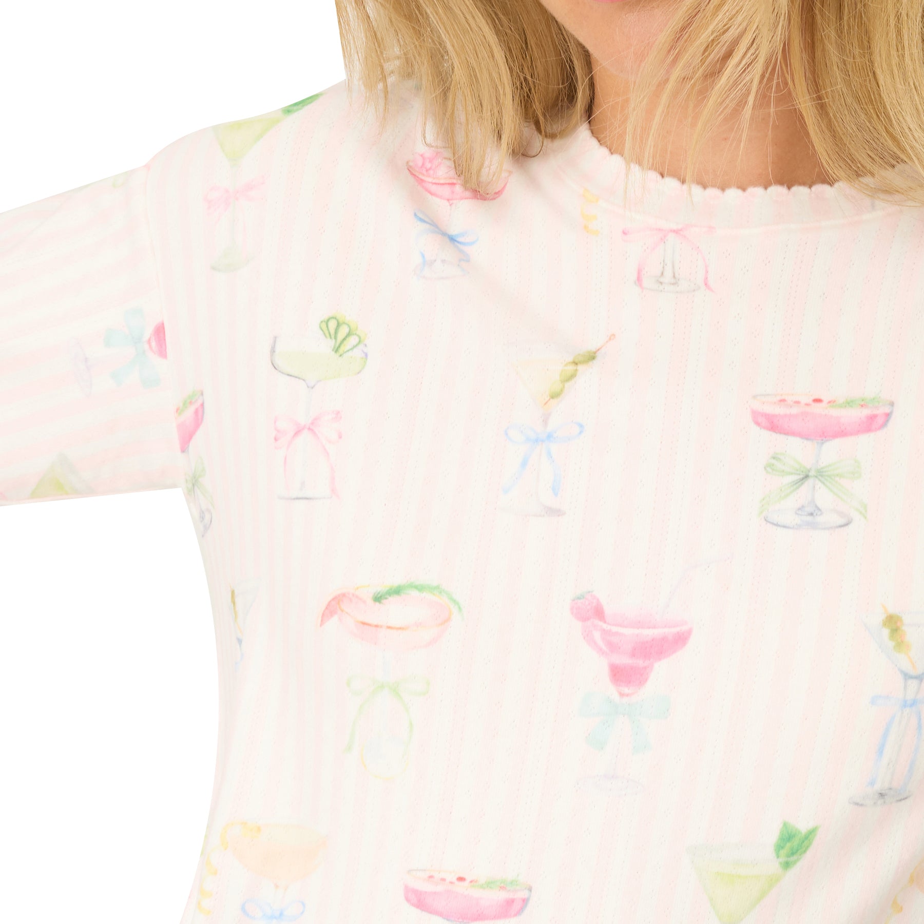 Detail of women’s pyjama top neckline showing cocktail glass print on light pink stripes.