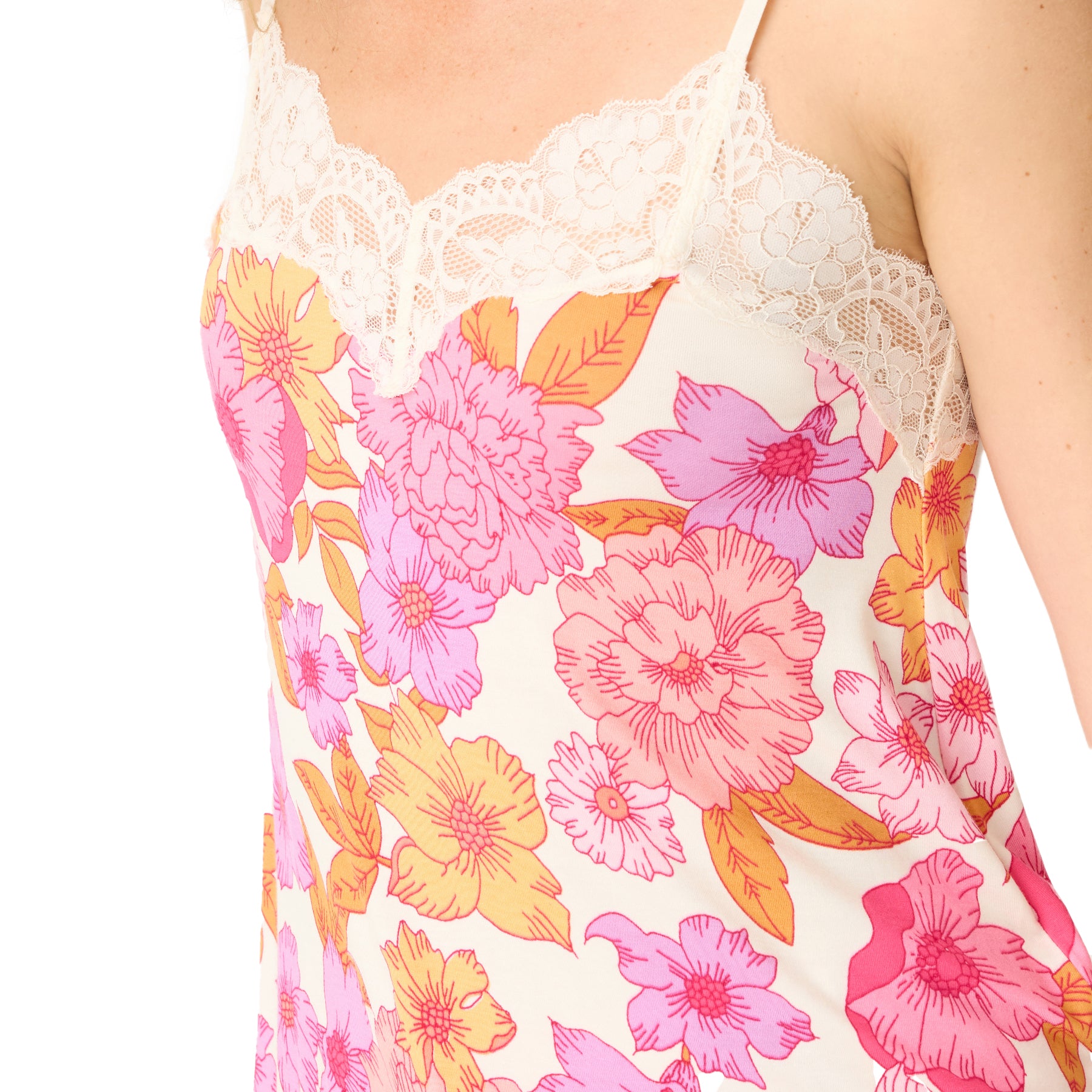 Detail view of a floral camisole top with delicate ivory lace trim at the neckline, featuring a bold pink, orange, and purple flower pattern.