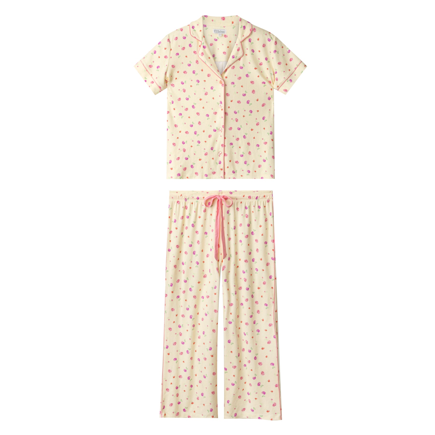 Cream floral pyjama set flat lay with short sleeve button-up top and drawstring waist pants on white background