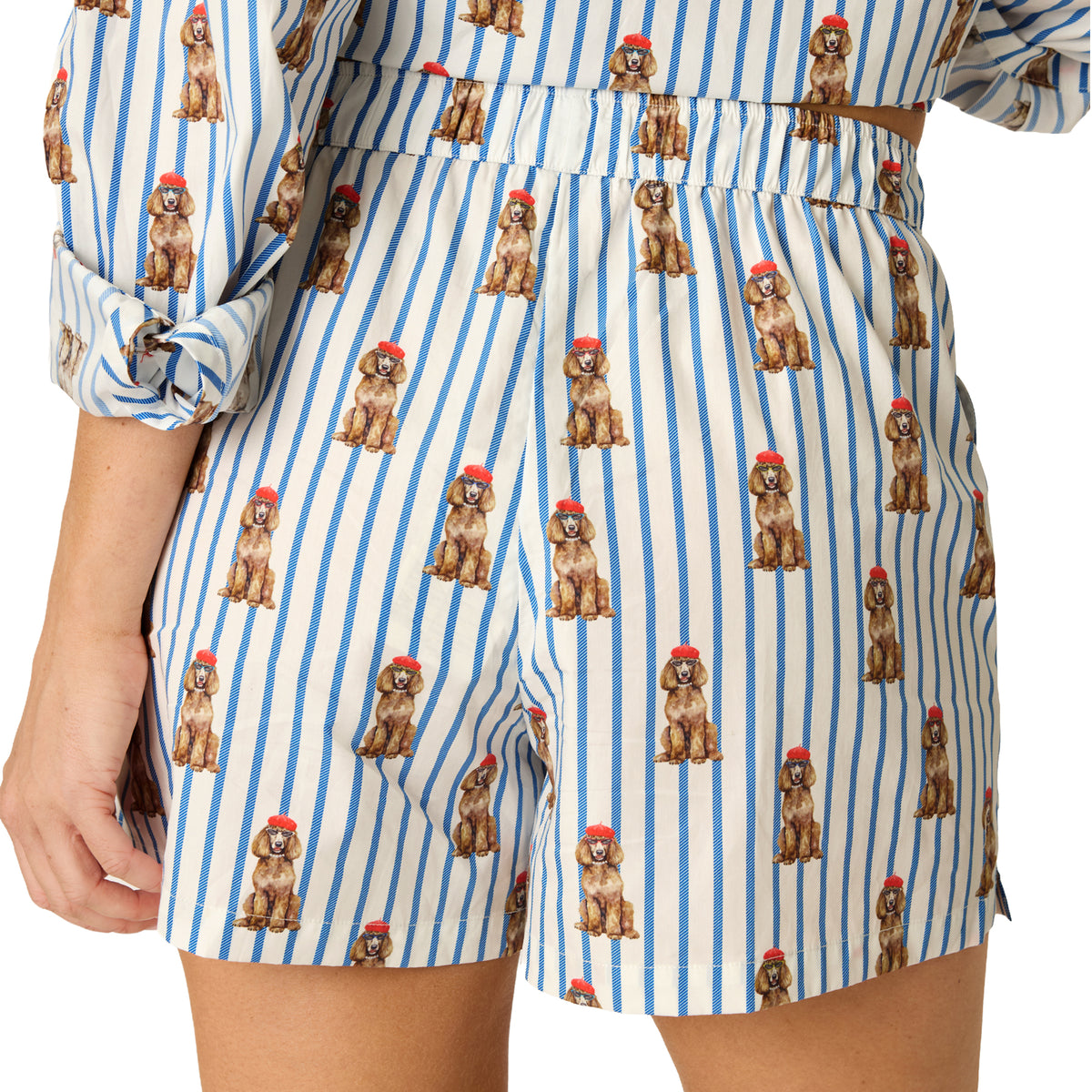 Close-up of pajama shorts showing the elastic waistband, red heart detail, buttons and dog print on blue stripes.