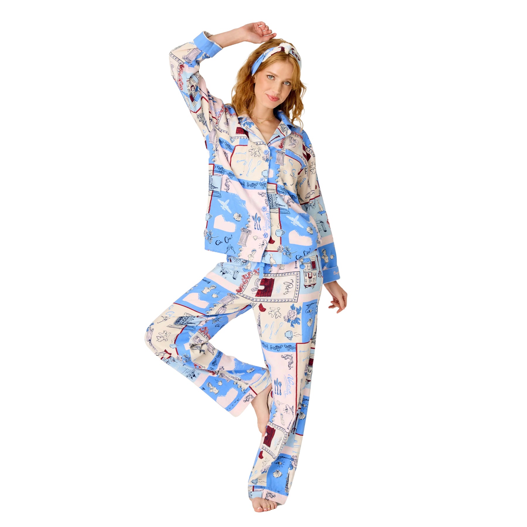 Woman wearing a blue, blush and cream Paris-inspired print pajama set with button-up top, relaxed pants and matching headband.