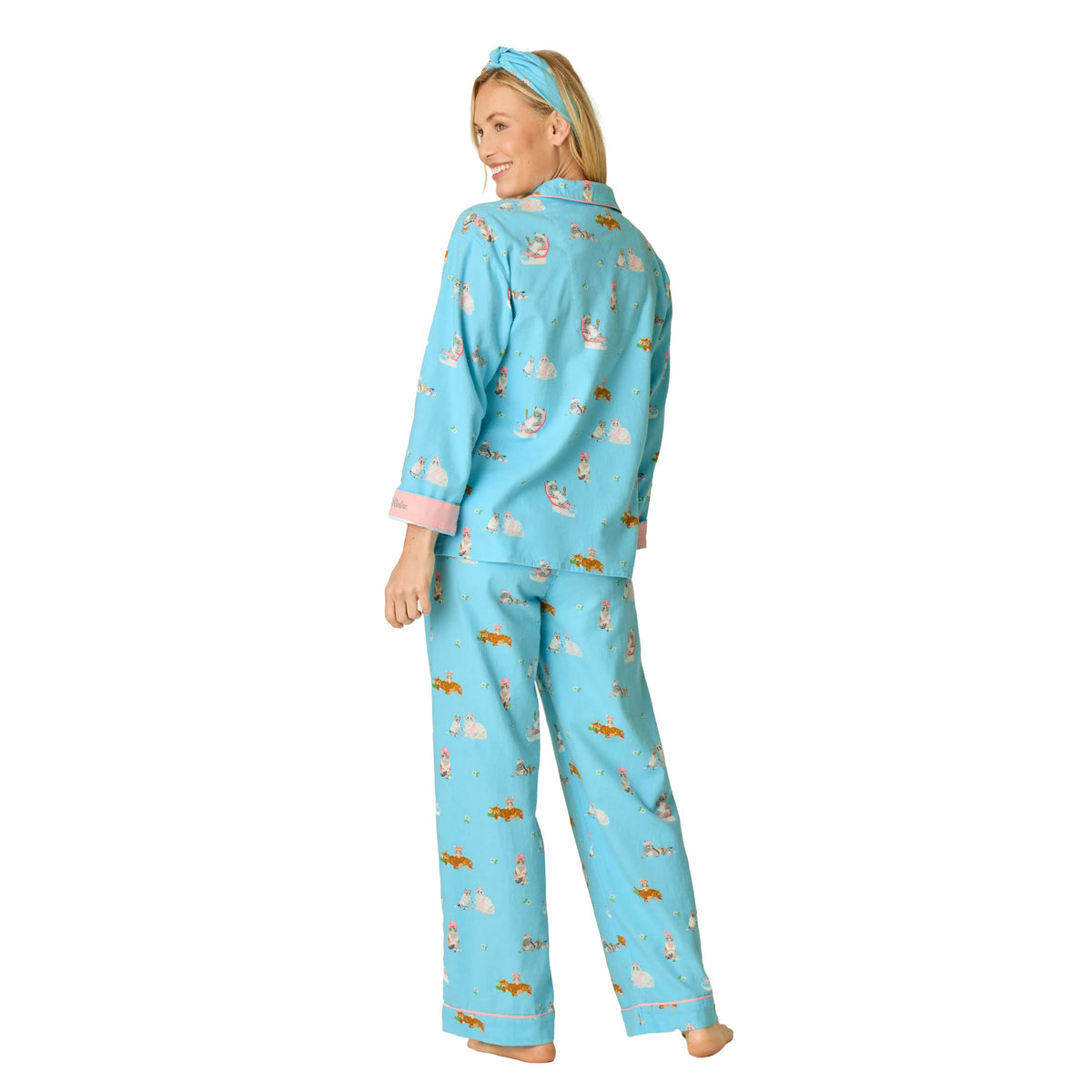 Model wearing PJ Salvage Paws & Relax blue cat print flannel pyjama set with pink trim and relaxed straight-leg pants, back view.