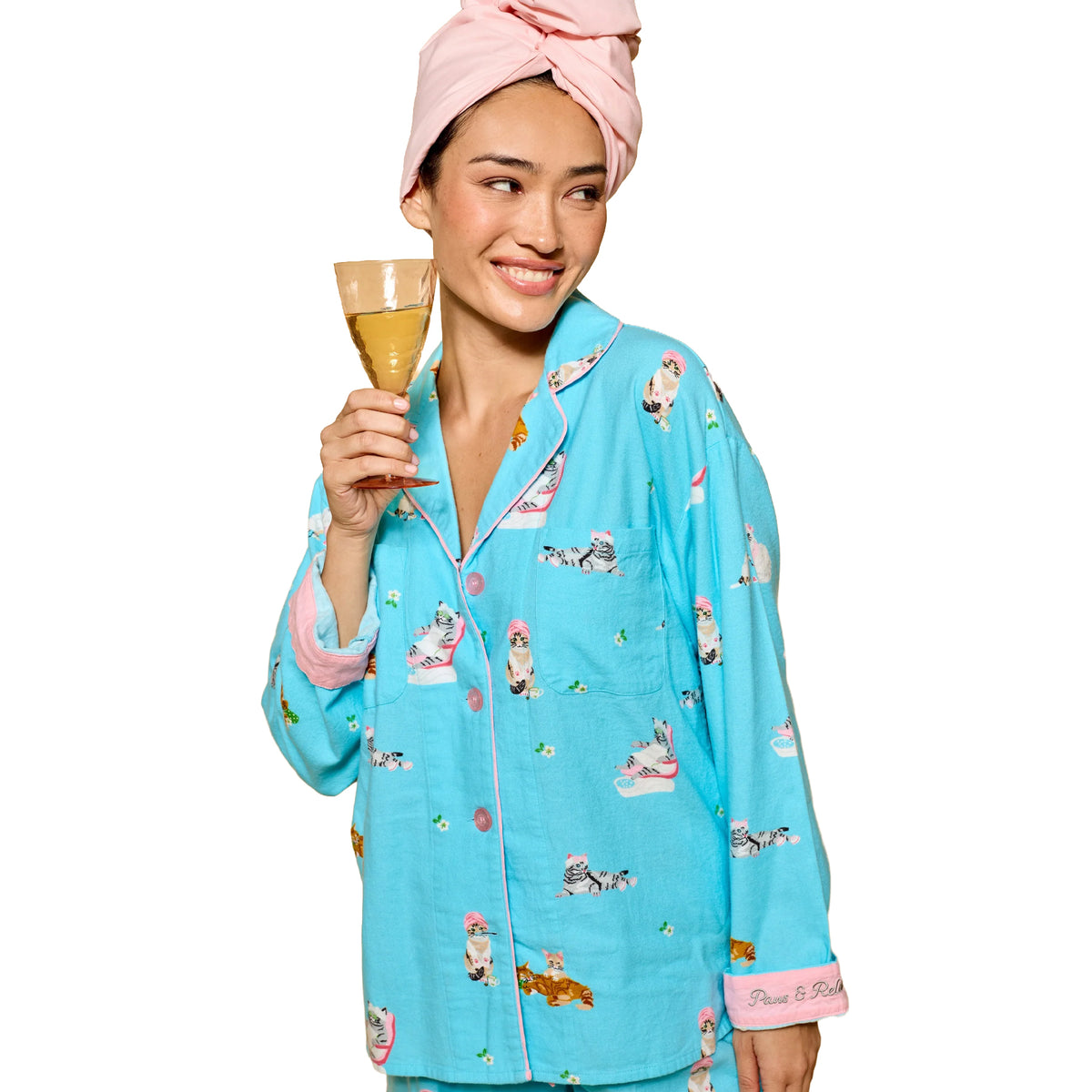 Model wearing PJ Salvage Paws & Relax blue cat print button-down pyjama top with pink piping and embroidered cuffs, front view.