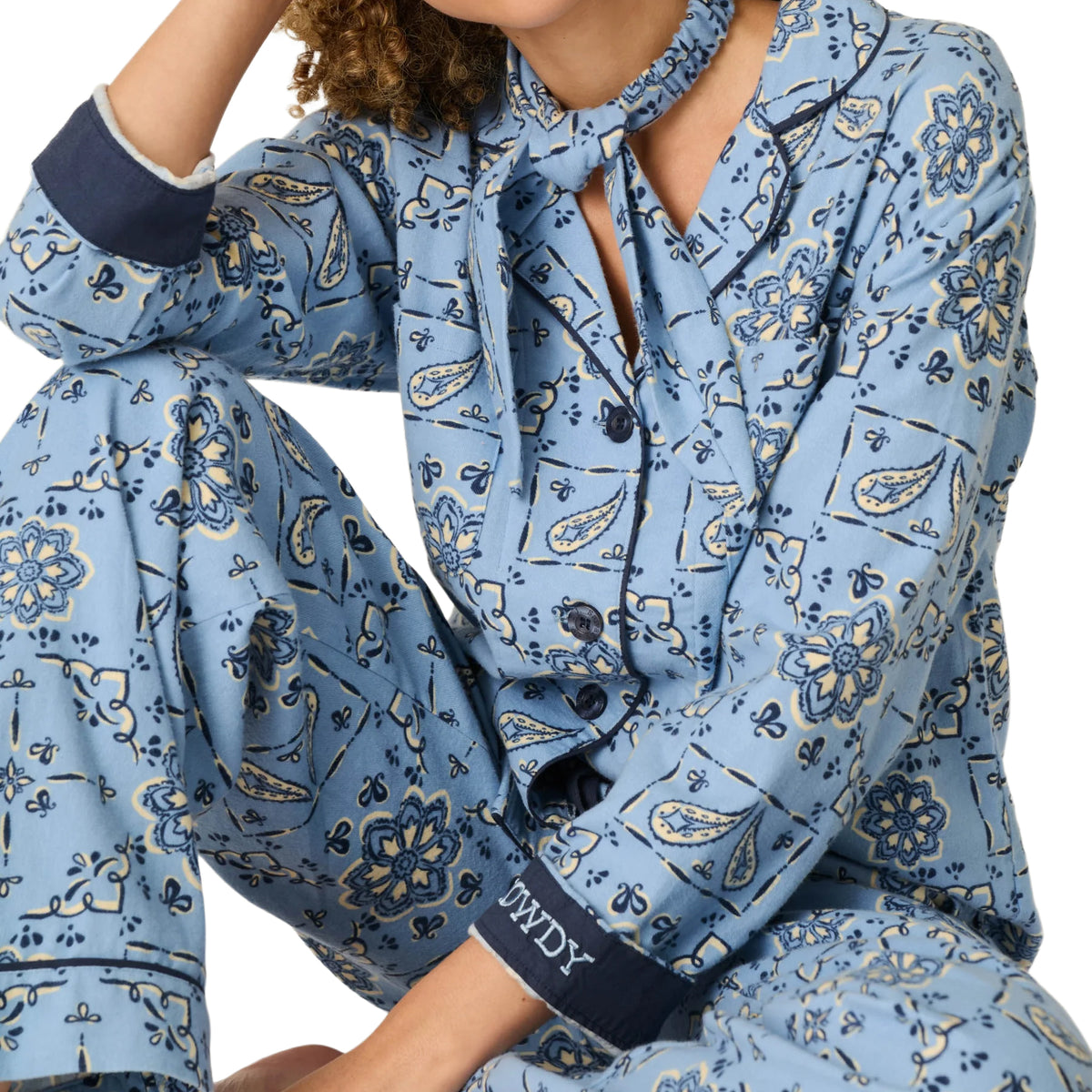 Close-up of PJ Salvage Howdy flannel pyjama set featuring blue floral paisley print, button-down top, navy piping and matching scarf.