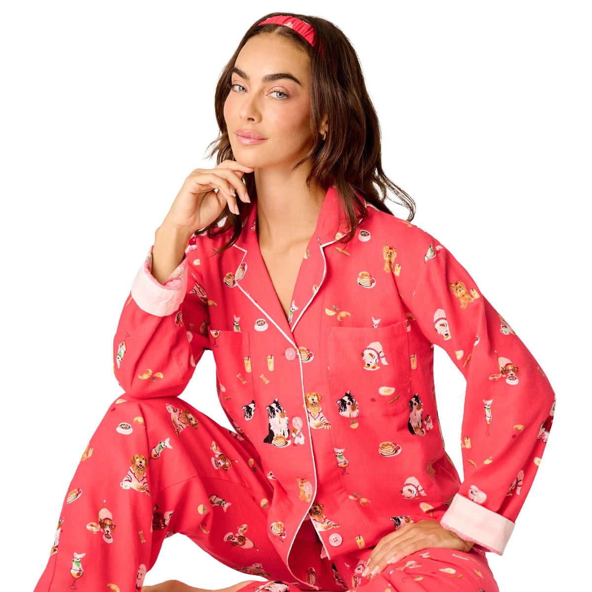 Model wearing PJ Salvage Brunch Pups flannel pyjama set with white piping, dog print and matching headband, seated front view.