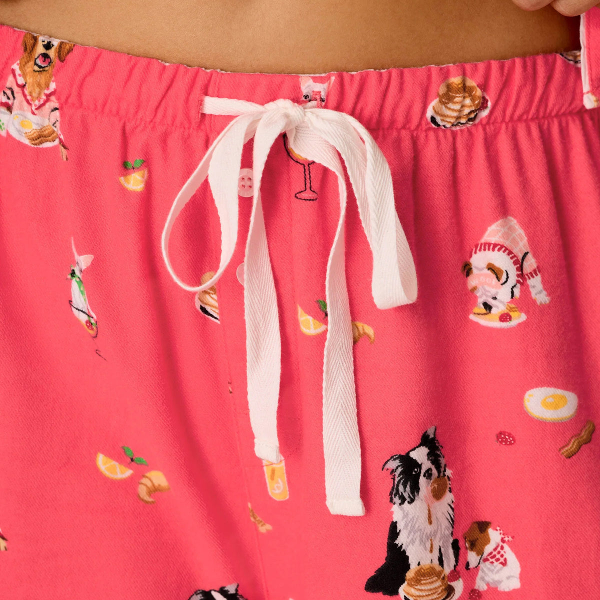Close-up of PJ Salvage Brunch Pups flannel pyjama pants featuring elastic waistband, white drawstring and colourful dog print.