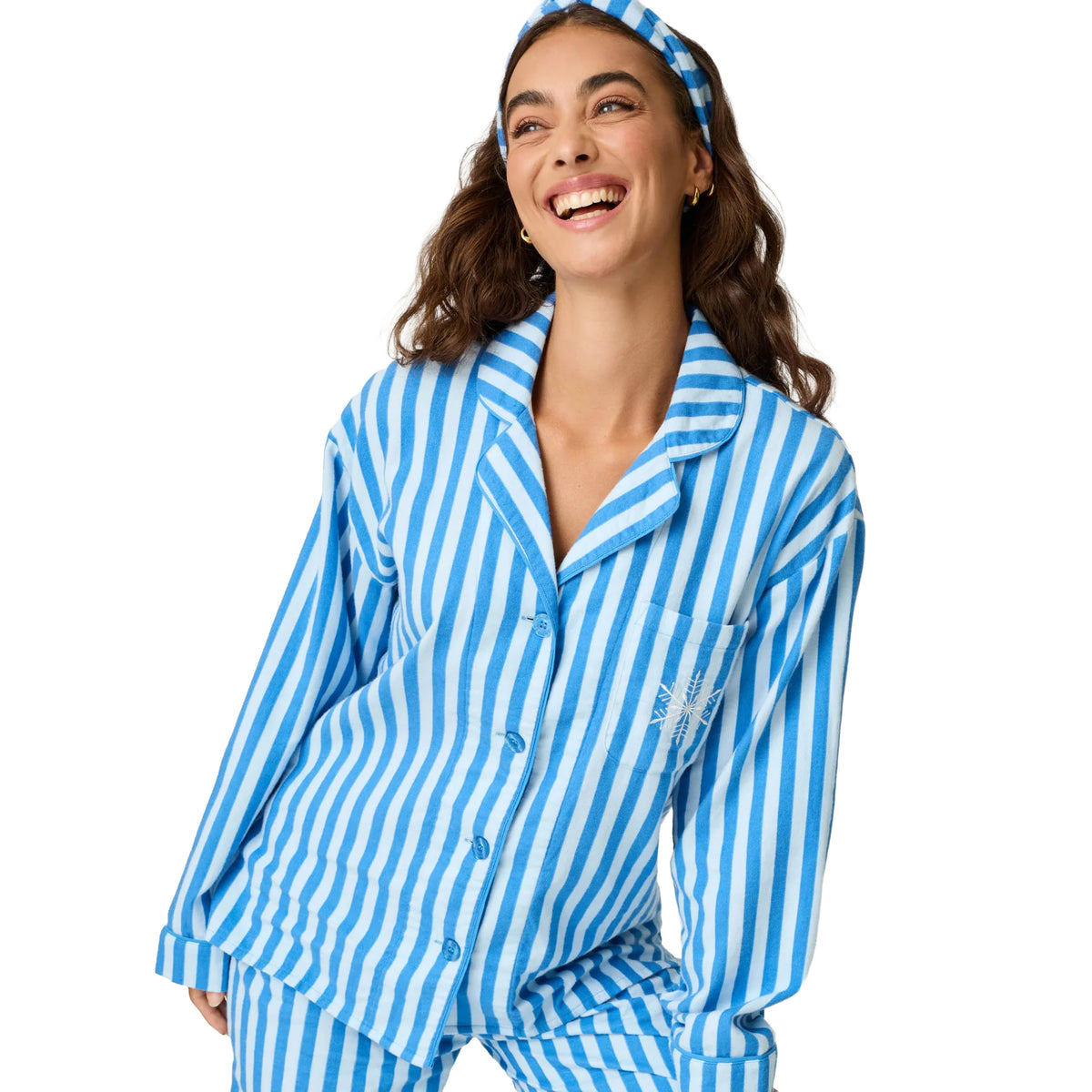 Close-up of model wearing blue and white striped flannel pajama top with button front and snowflake embroidery.