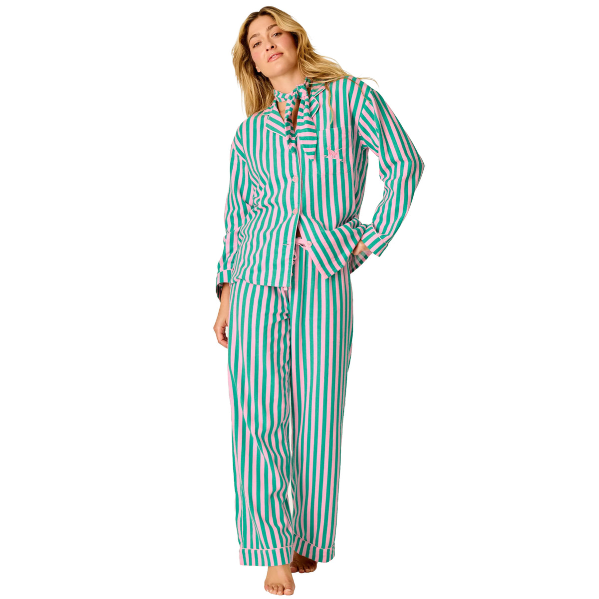 Model wearing pink and green striped PJ Salvage flannel pajama set with button-up top, matching pants and neck scarf, front view.