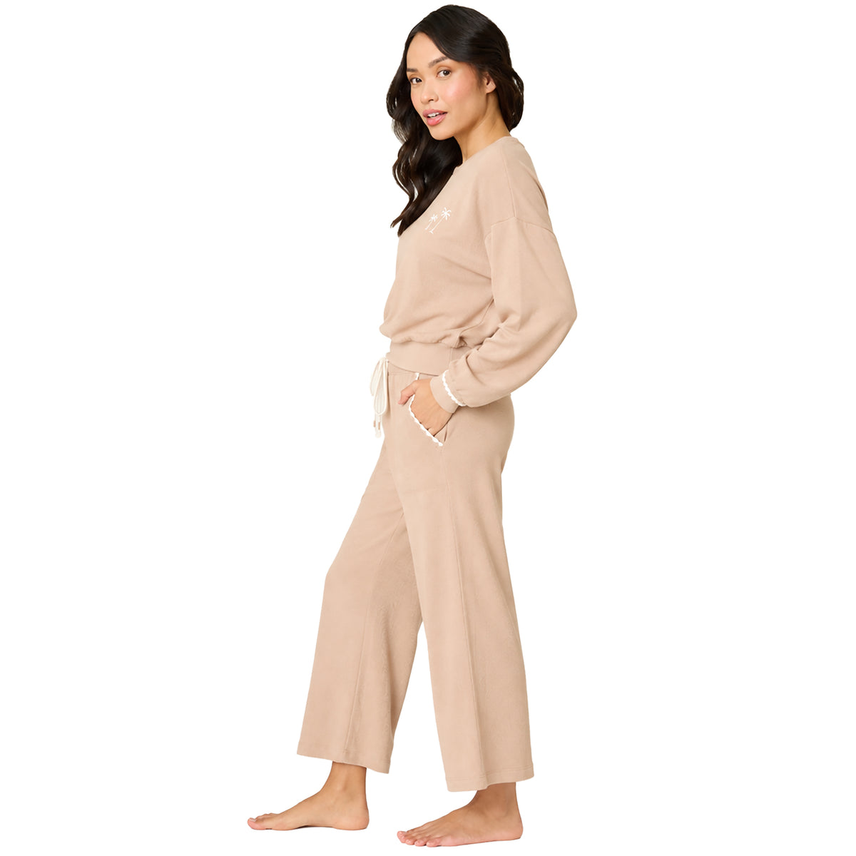 Side view of a women's warm taupe knit lounge set with a relaxed fit sweatshirt, embroidered palm tree detail, and drawstring lounge pants.