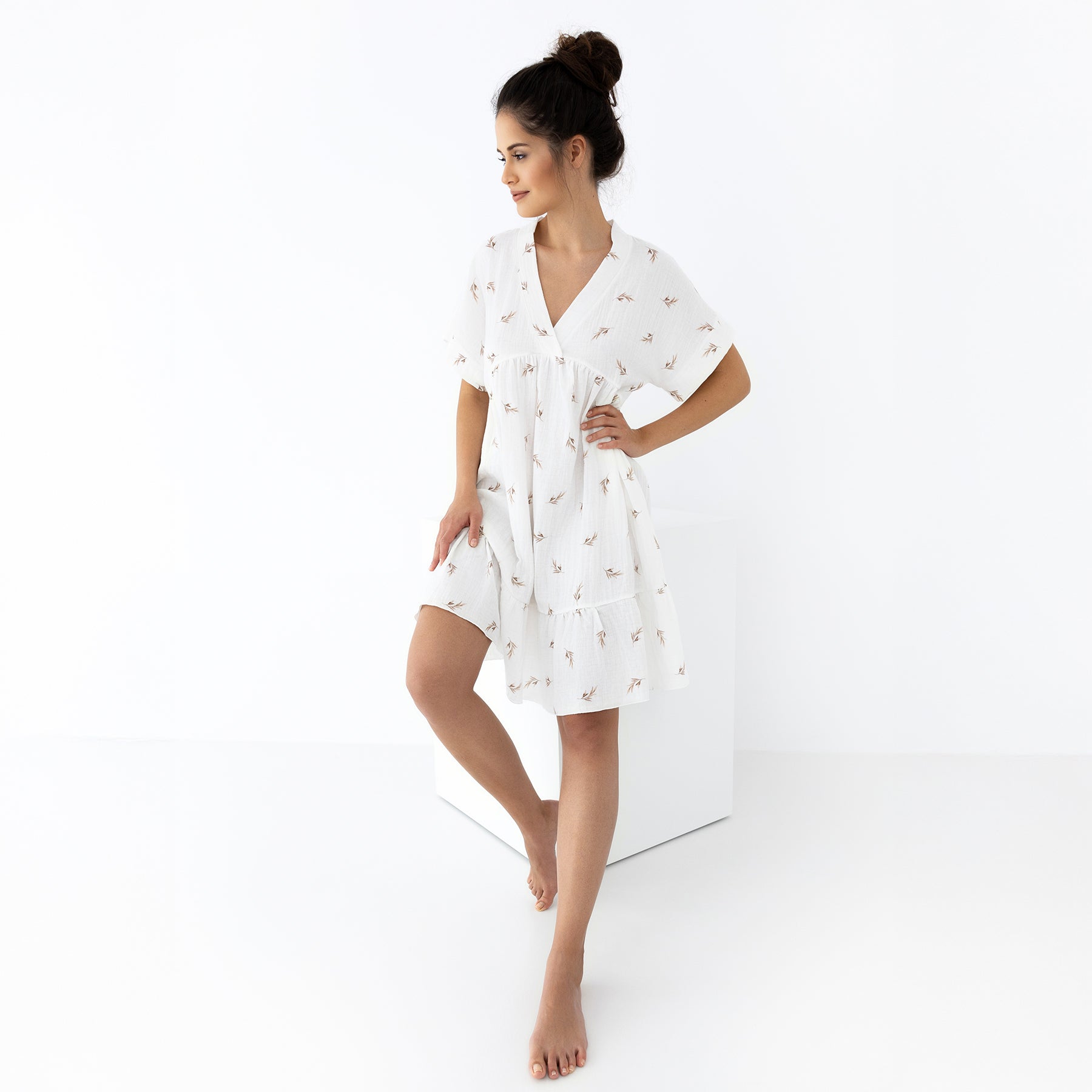 Full view of tiered ivory sleep dress with short sleeves and taupe botanical print, in a relaxed walking pose