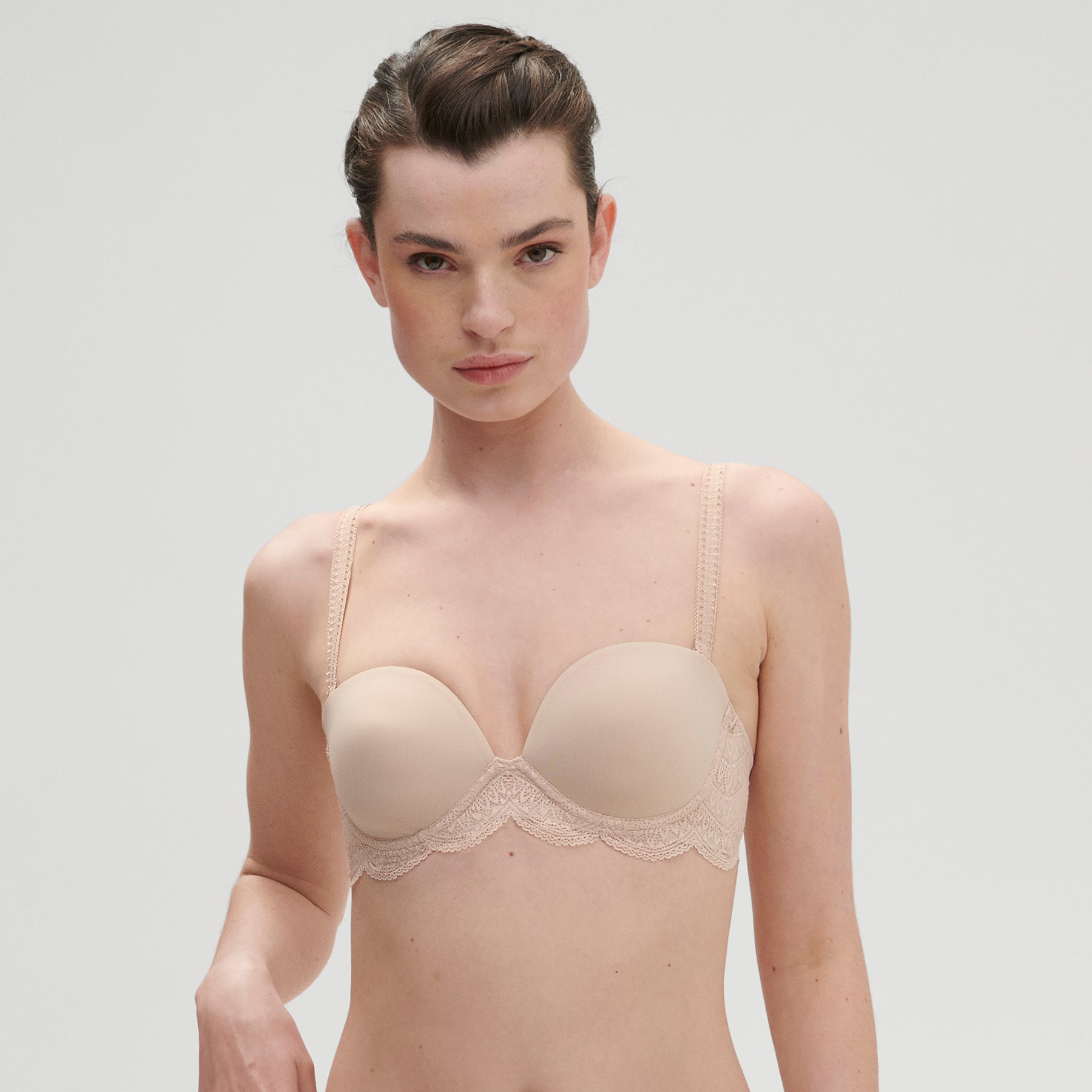 Strapless bra in nude peau rose, on model, front view.