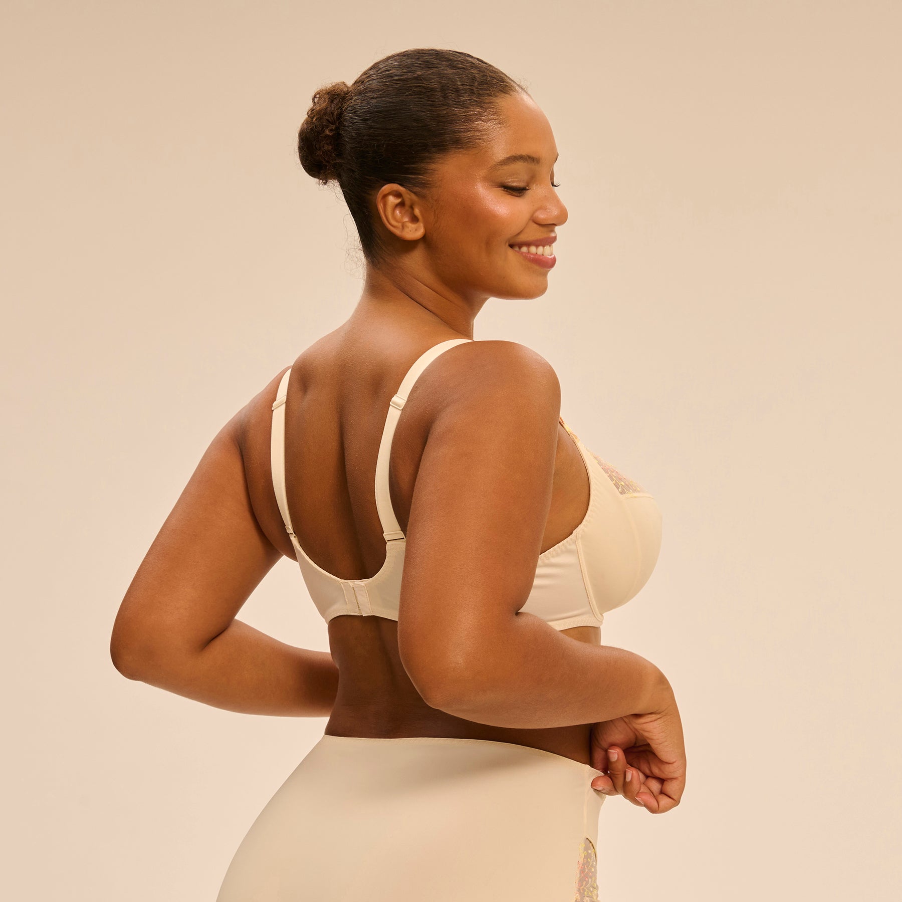 3 Part full cup bra in pale yellow peach pampa with contrast coral pink embroidery along the cups. Rear view on model.