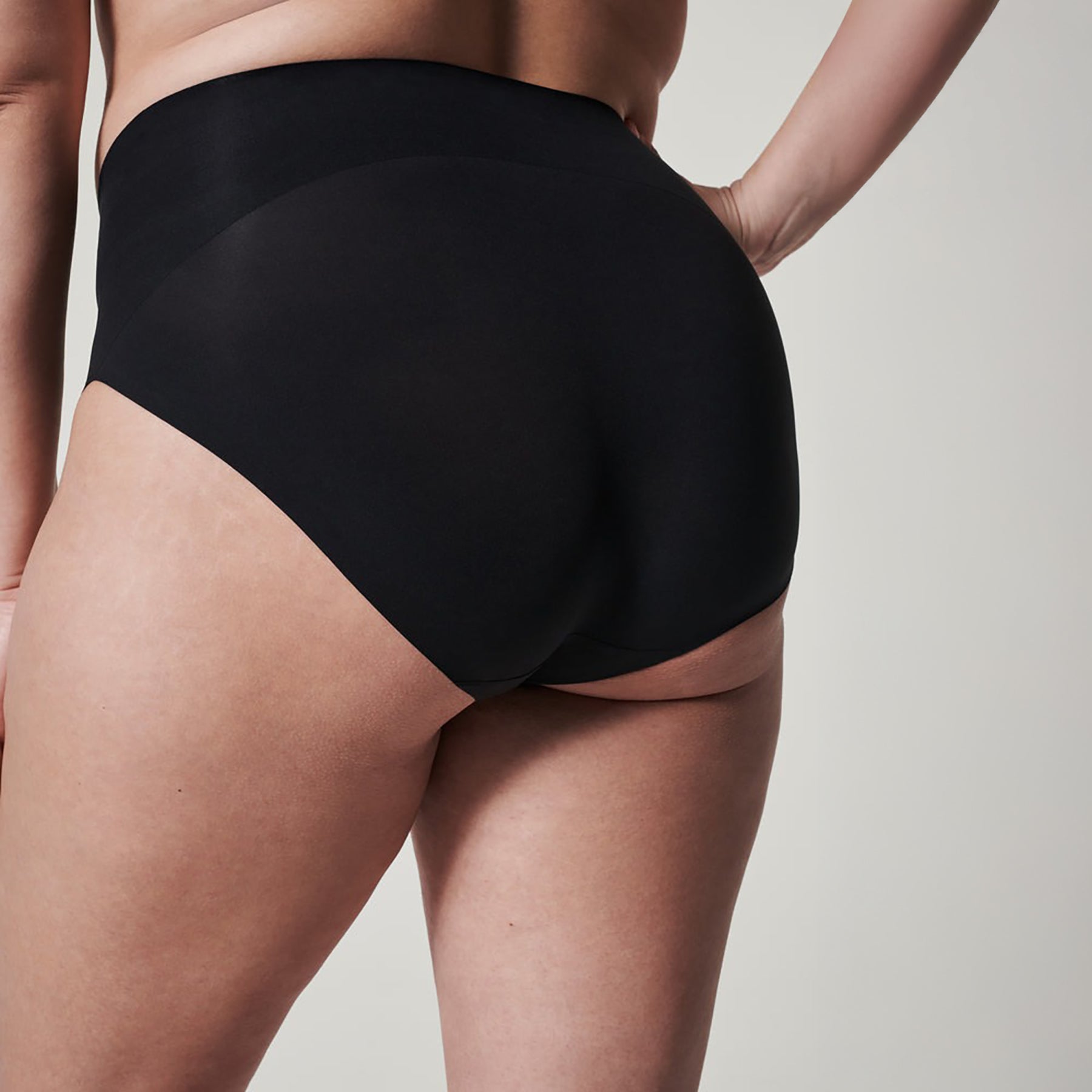 Back view of SPANX High-Waist Seamless Brief in black showing contouring fit, seamless edges, and smoothing coverage.