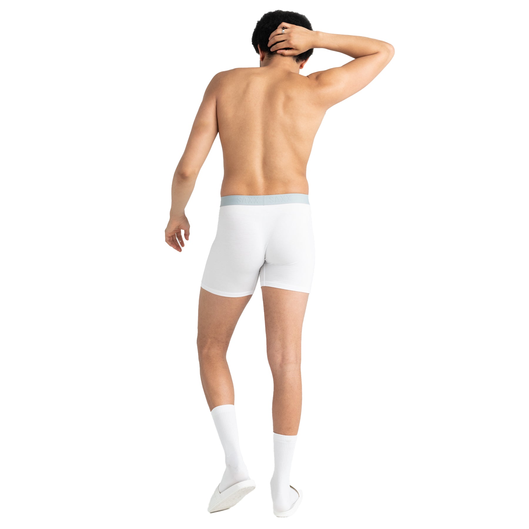 Man wearing white boxer briefs and socks on a white background