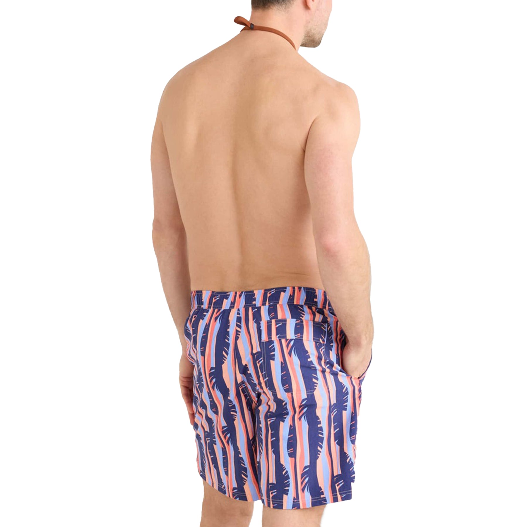 Back view of a man wearing SAXX Tropic Stripe swim shorts with palm leaf pattern.