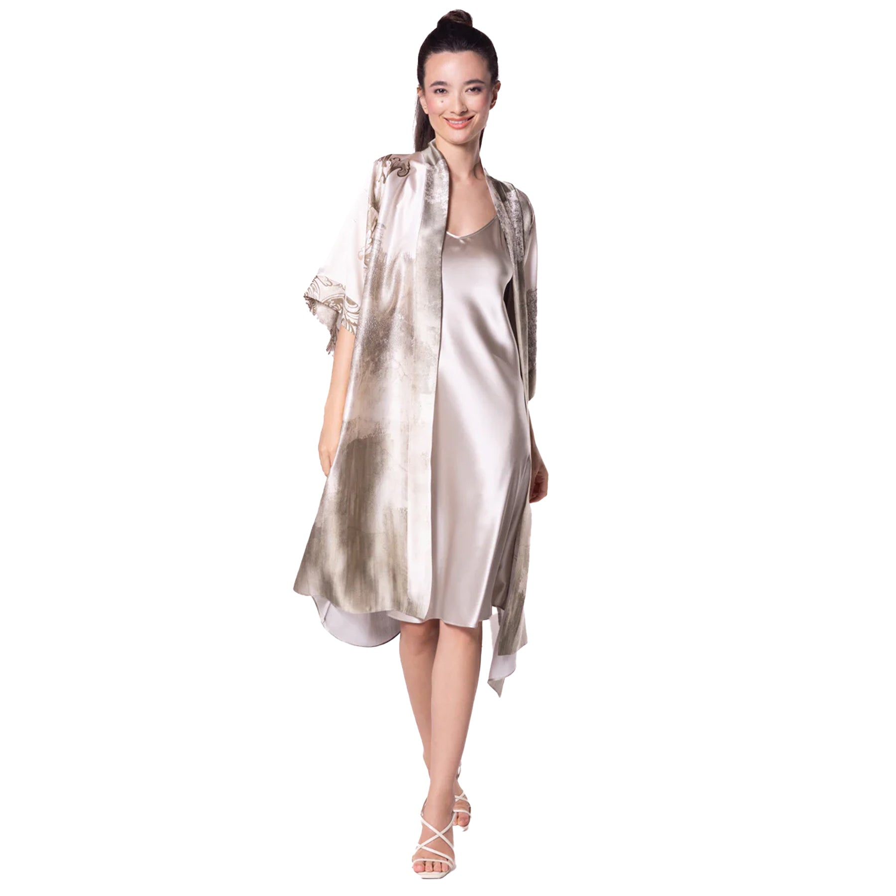 Woman in a satin robe and slip dress, featuring a watercolor-like wash of beige and taupe with elegant sheen.
