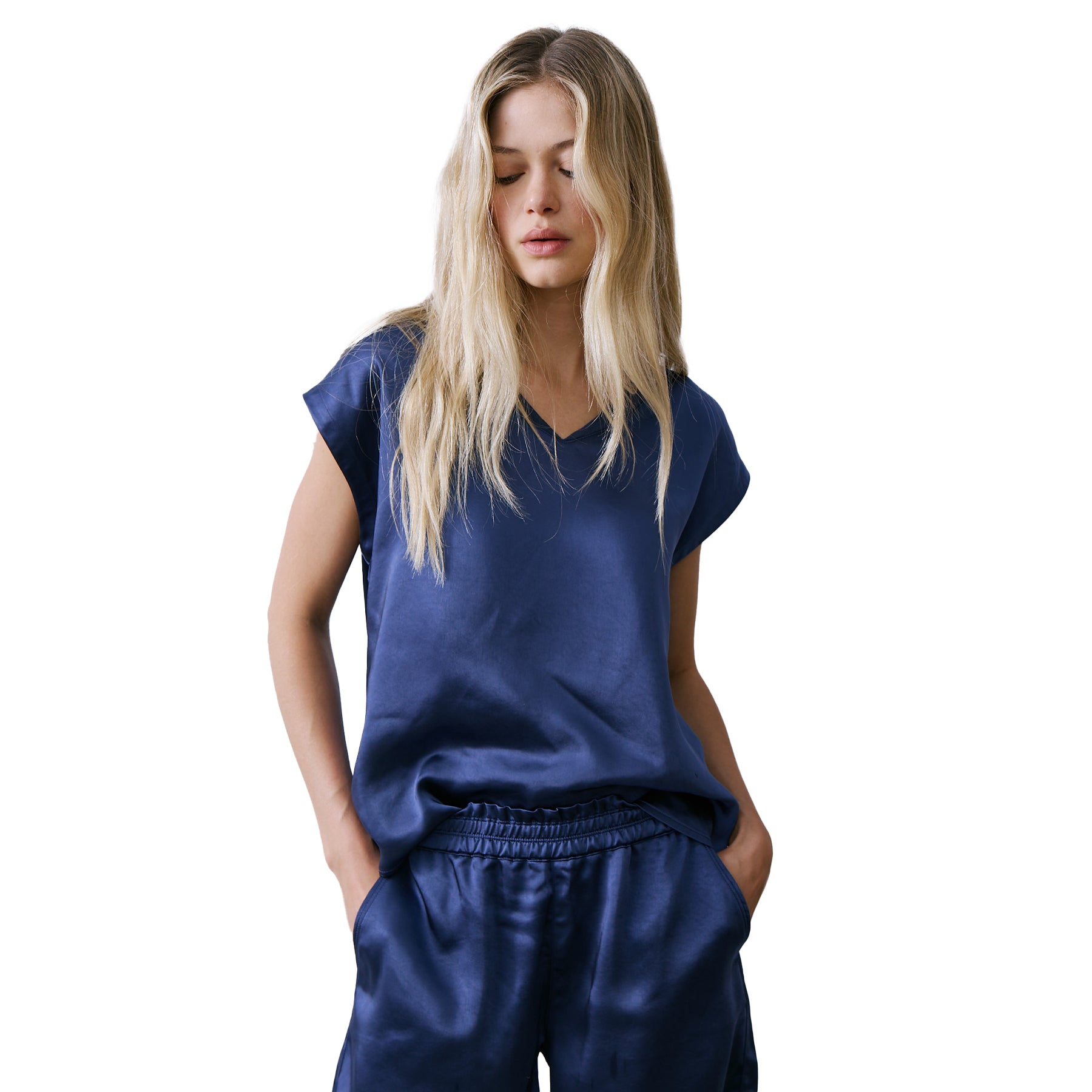 Model wearing navy satin V-neck sleeveless top with relaxed fit and silky finish.