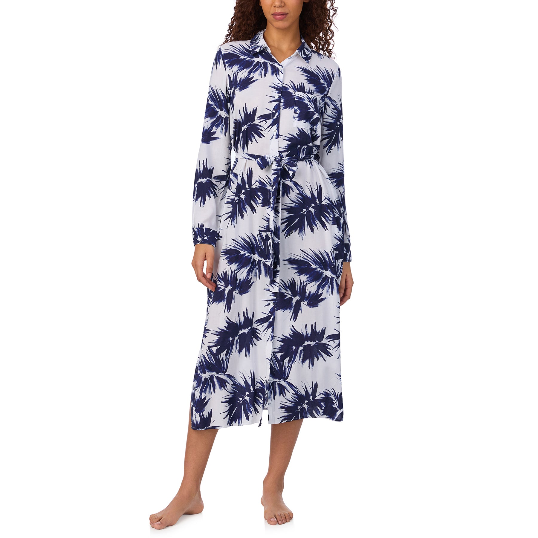Full front view of model wearing a belted long shirt dress with navy palm print and button-down front.