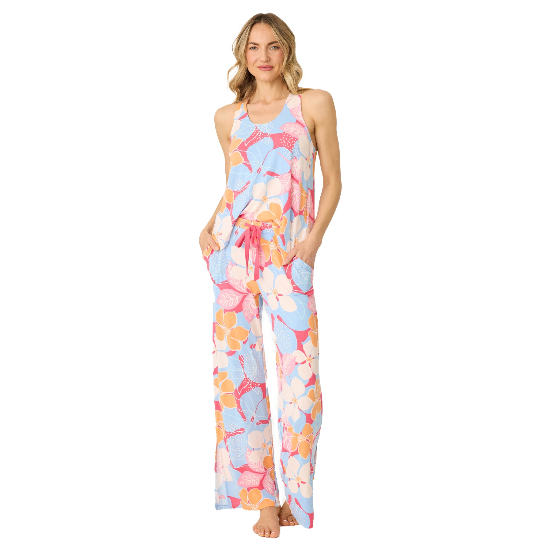 Full front view of a woman standing in a vibrant floral print pajama set with drawstring pants and tank top.