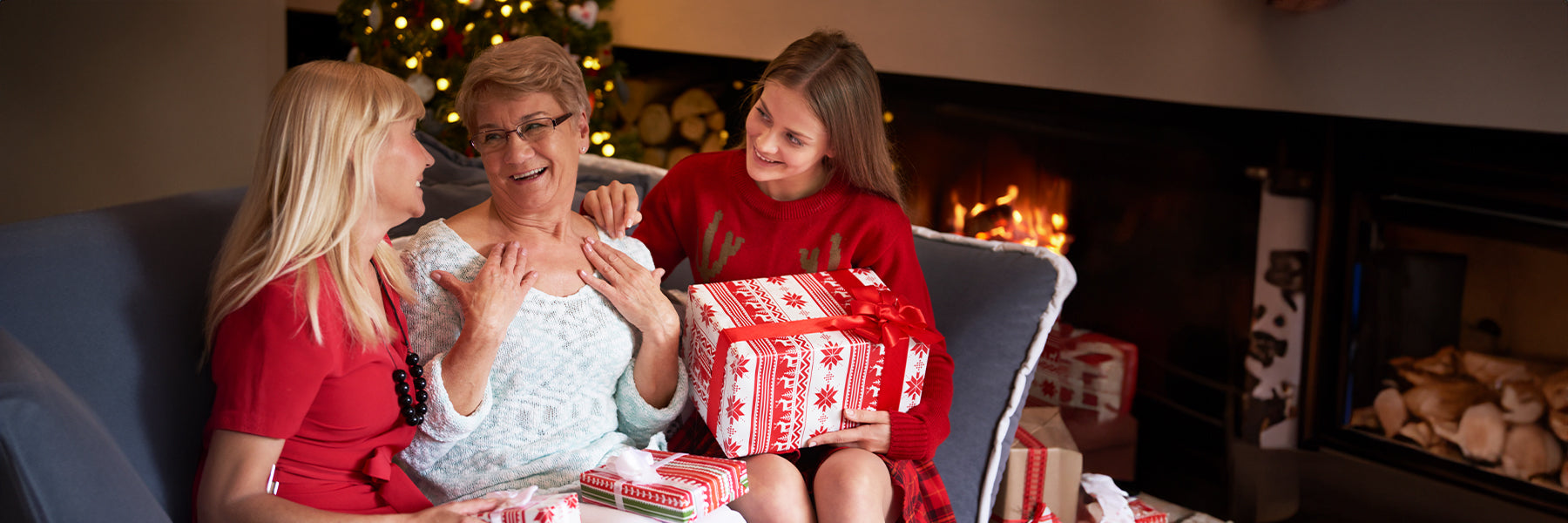 Two women giving a Christmas Present to their mom