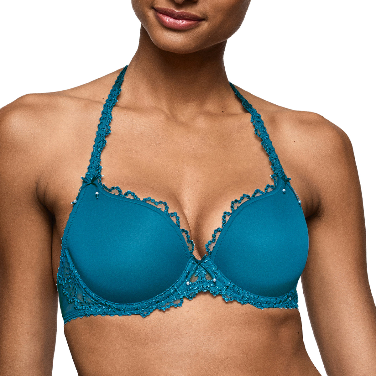 Close-up of a peacock teal padded bra featuring smooth cups, lace-trimmed neckline, decorative bows and delicate pearl accents.