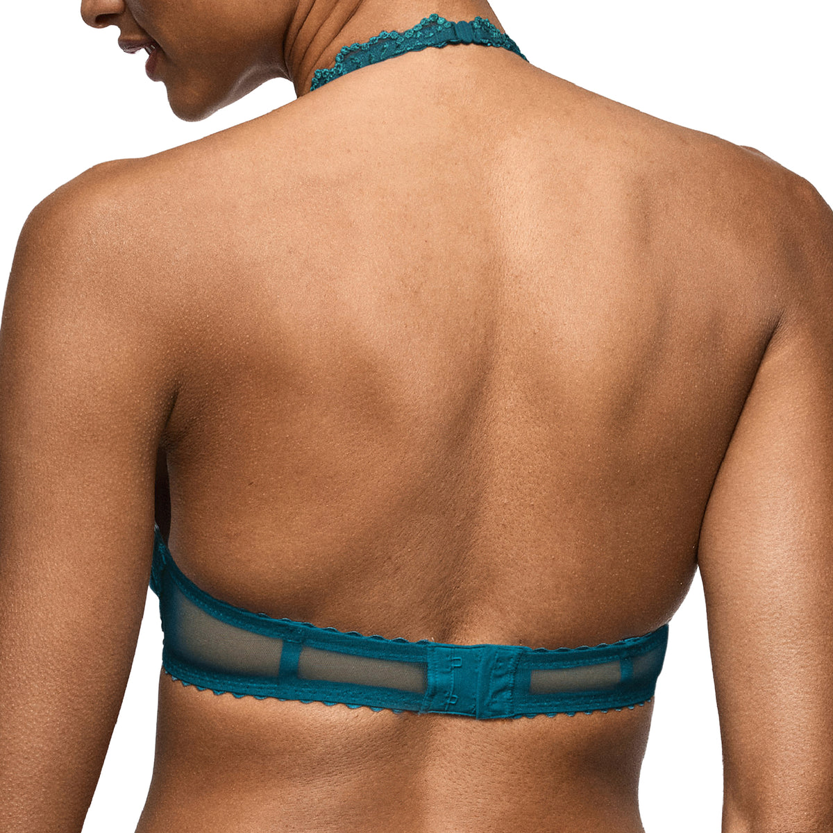 Close-up back view of a peacock teal bra with a sheer mesh band and hook-and-eye closure.