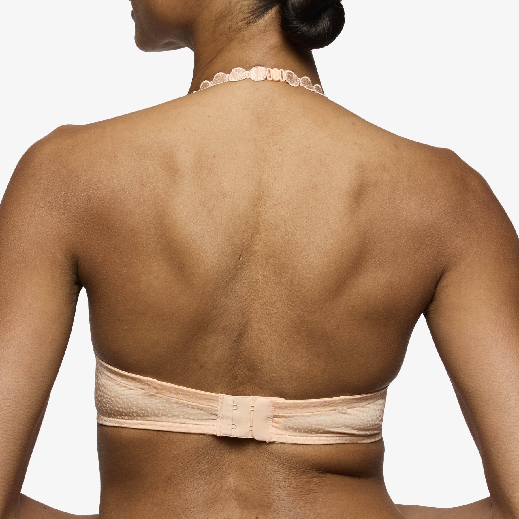 Peach strapless bra back view with wide band and supportive hook-and-eye closure