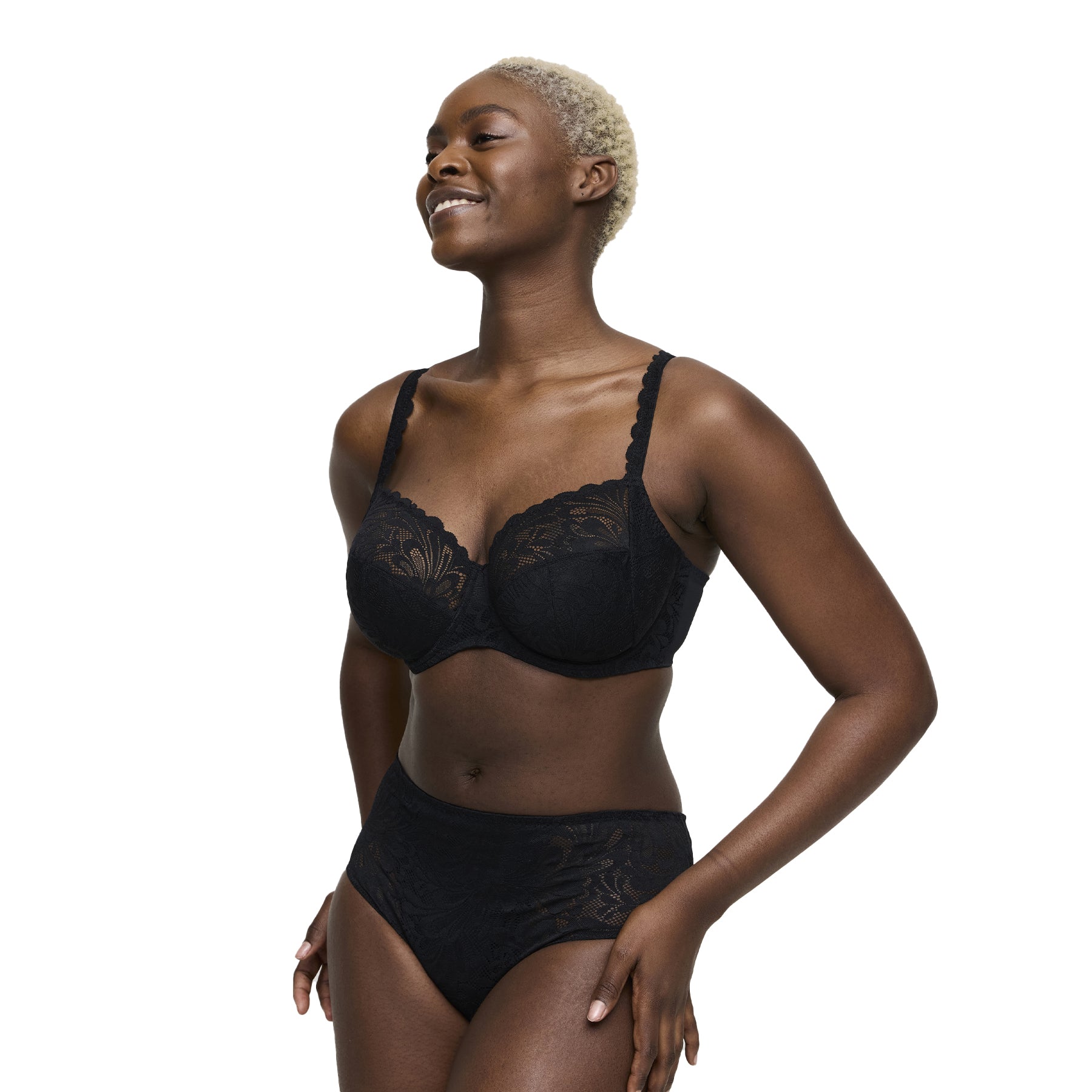 Woman wearing black lace underwired bra and matching high-waist brief, side angle.
