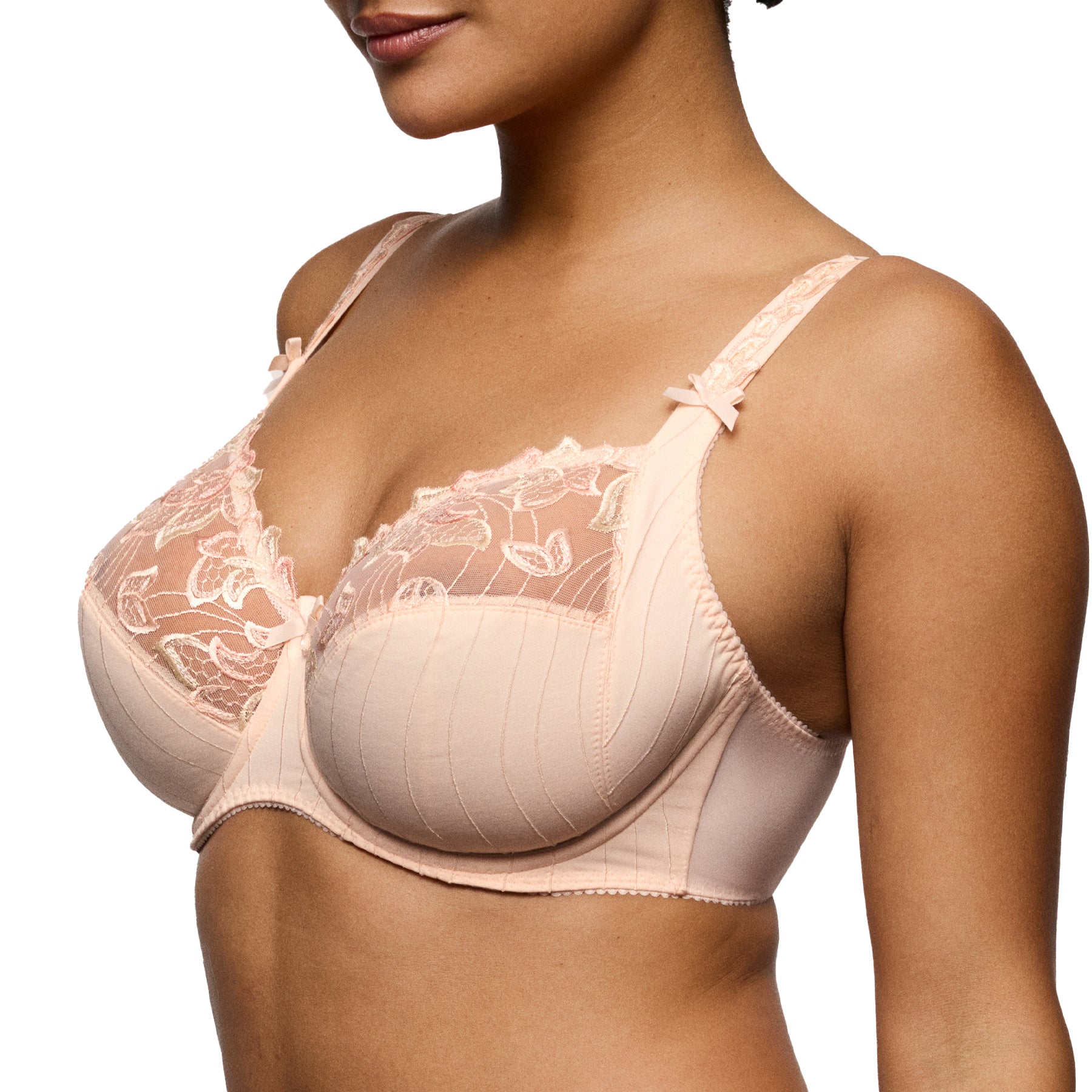 Angled side view of a blush lace underwire bra showing the contoured cups, supportive side panels, and elegant strap detailing.