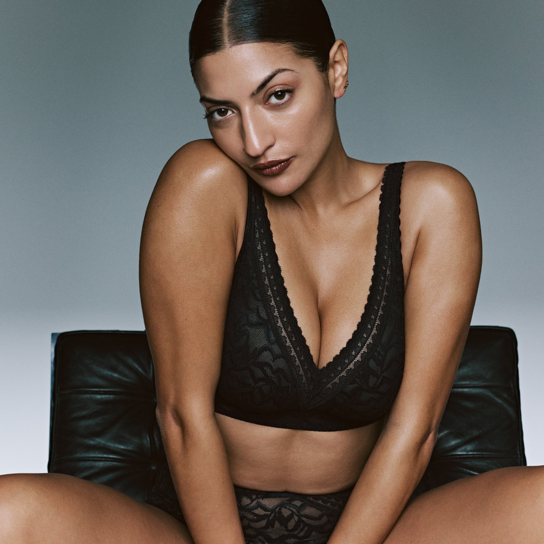 Model wearing the PrimaDonna Miyara wireless bra in black lace with a deep V-neckline and matching brief.
