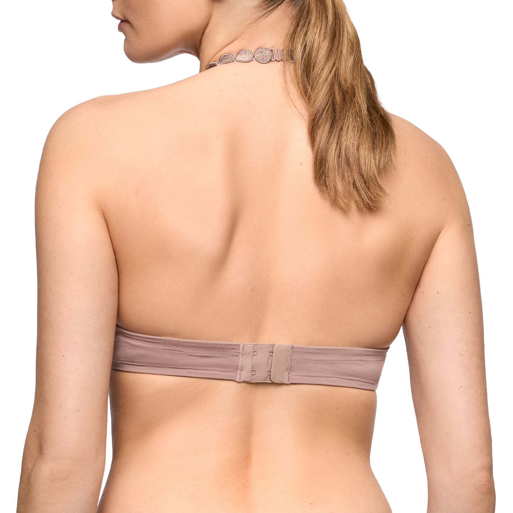 Back detail of cosmetic nude push-up bra showing smooth band design, hook closure, and decorative shoulder strap accents.