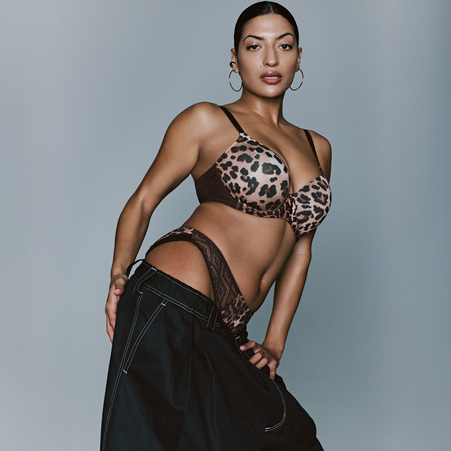Model wearing a leopard print underwire bra with brown lace side panels and matching brief.