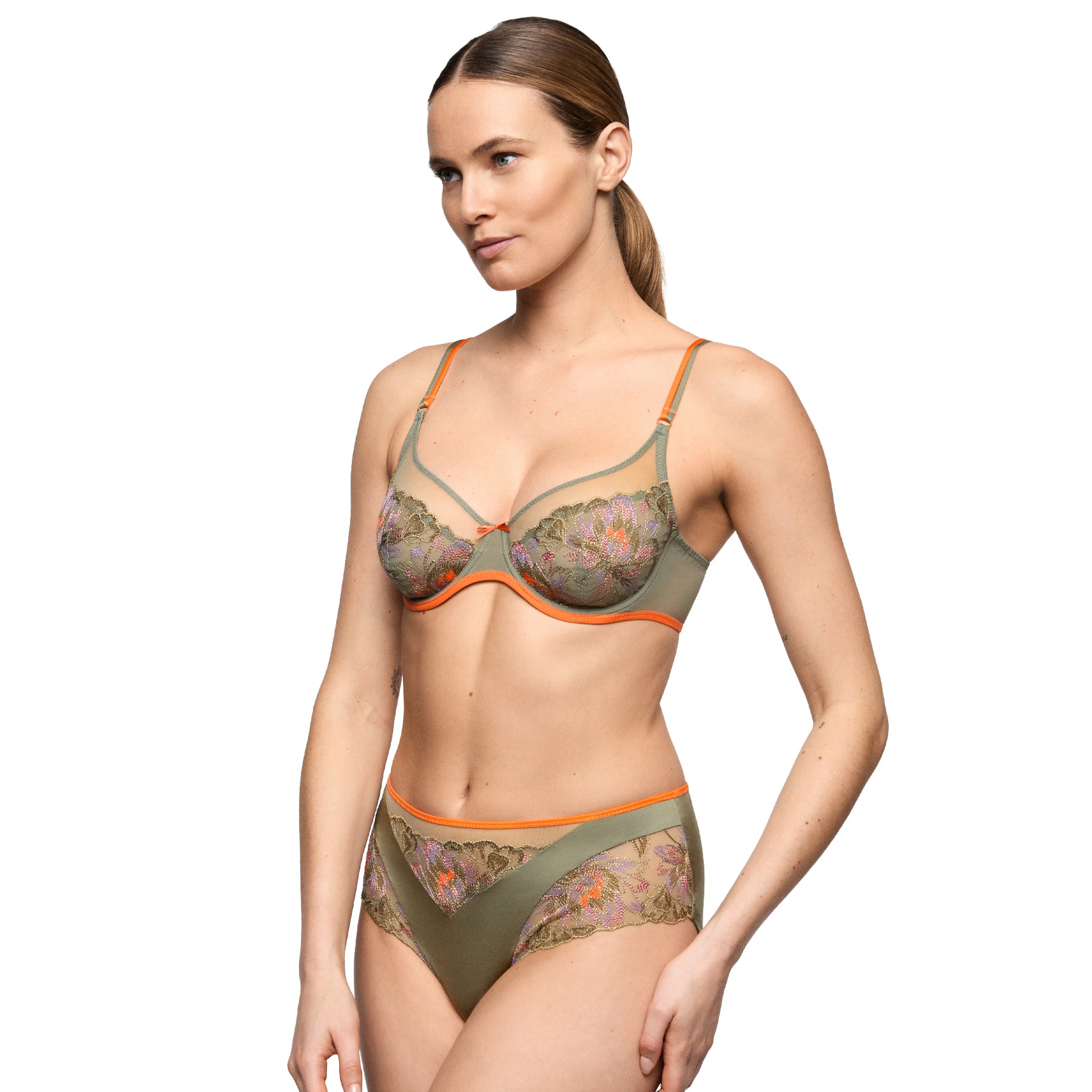 Model wearing an olive green embroidered bra with matching full brief featuring colourful floral lace and coral accents.