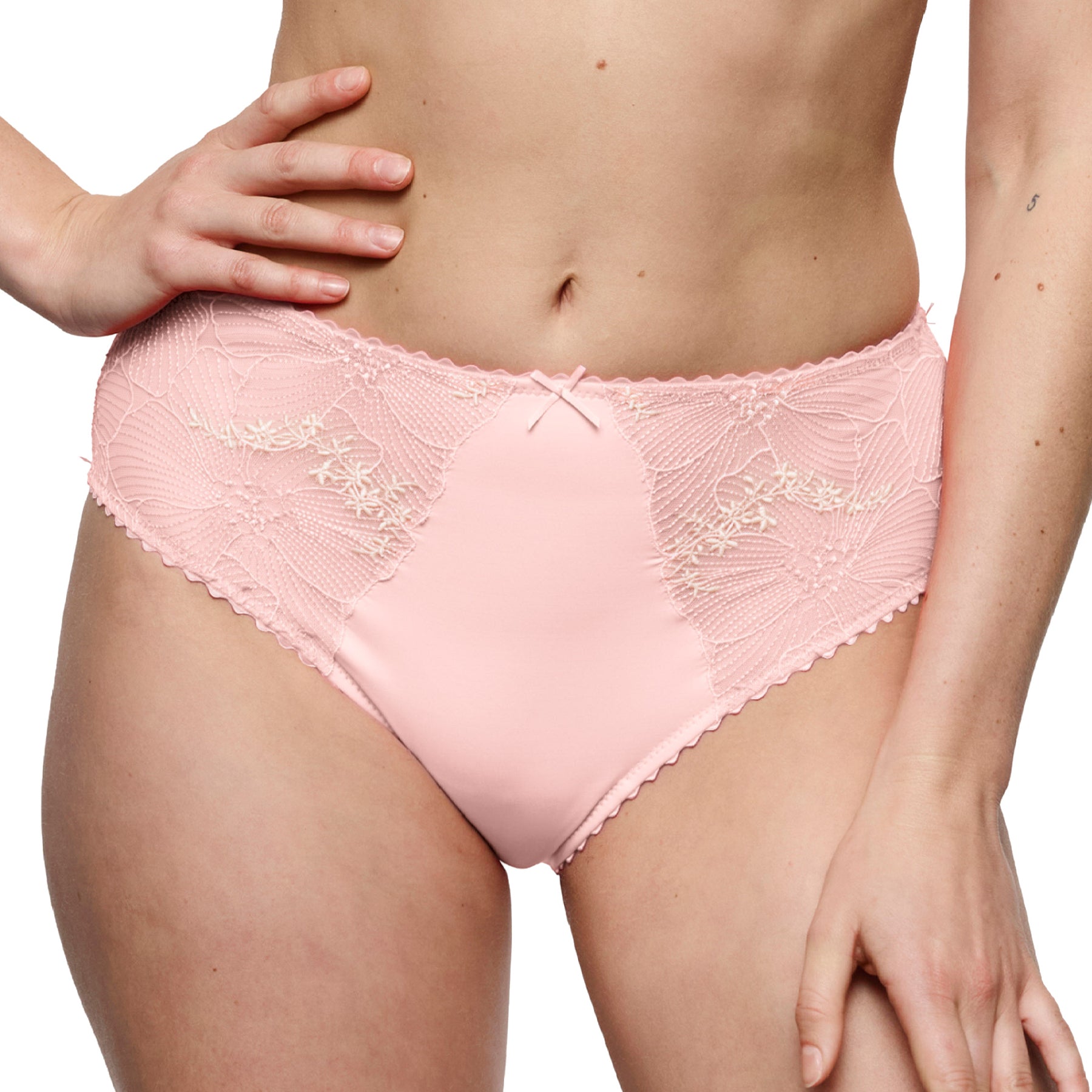 Model wearing a blush pink full brief with floral lace detailing, a smooth microfiber front, and comfortable full coverage