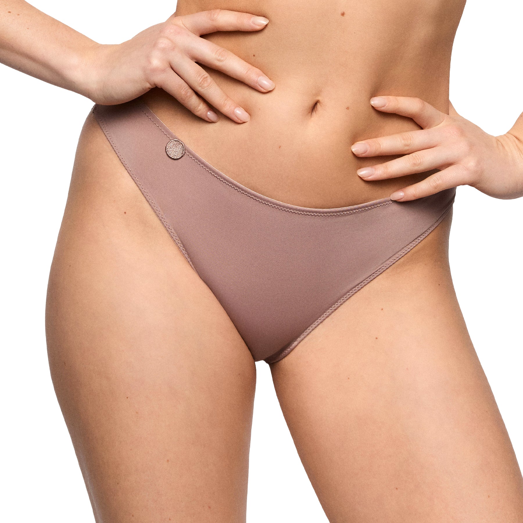 Close-up of cosmetic nude bikini brief showing soft fabric, delicate trim, and elegant side charm detail.