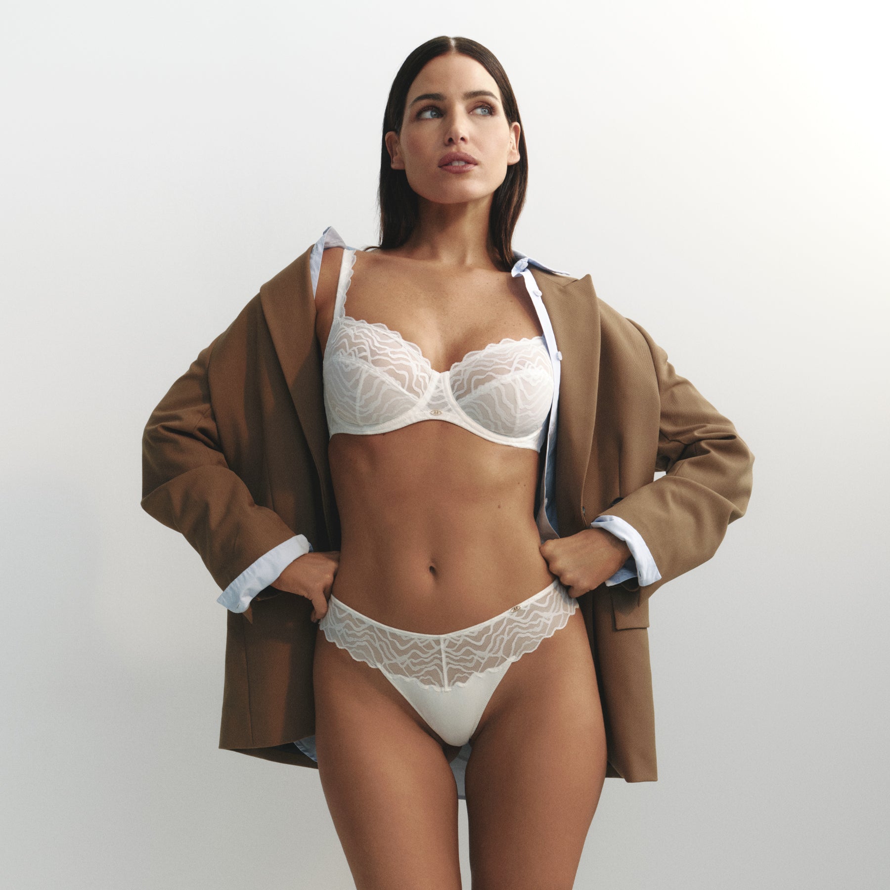 Model wearing the Marie Jo natural white lingerie set with an underwire bra and matching thong featuring sheer embroidered lace, smooth microfiber panels, and a modern, feminine silhouette.